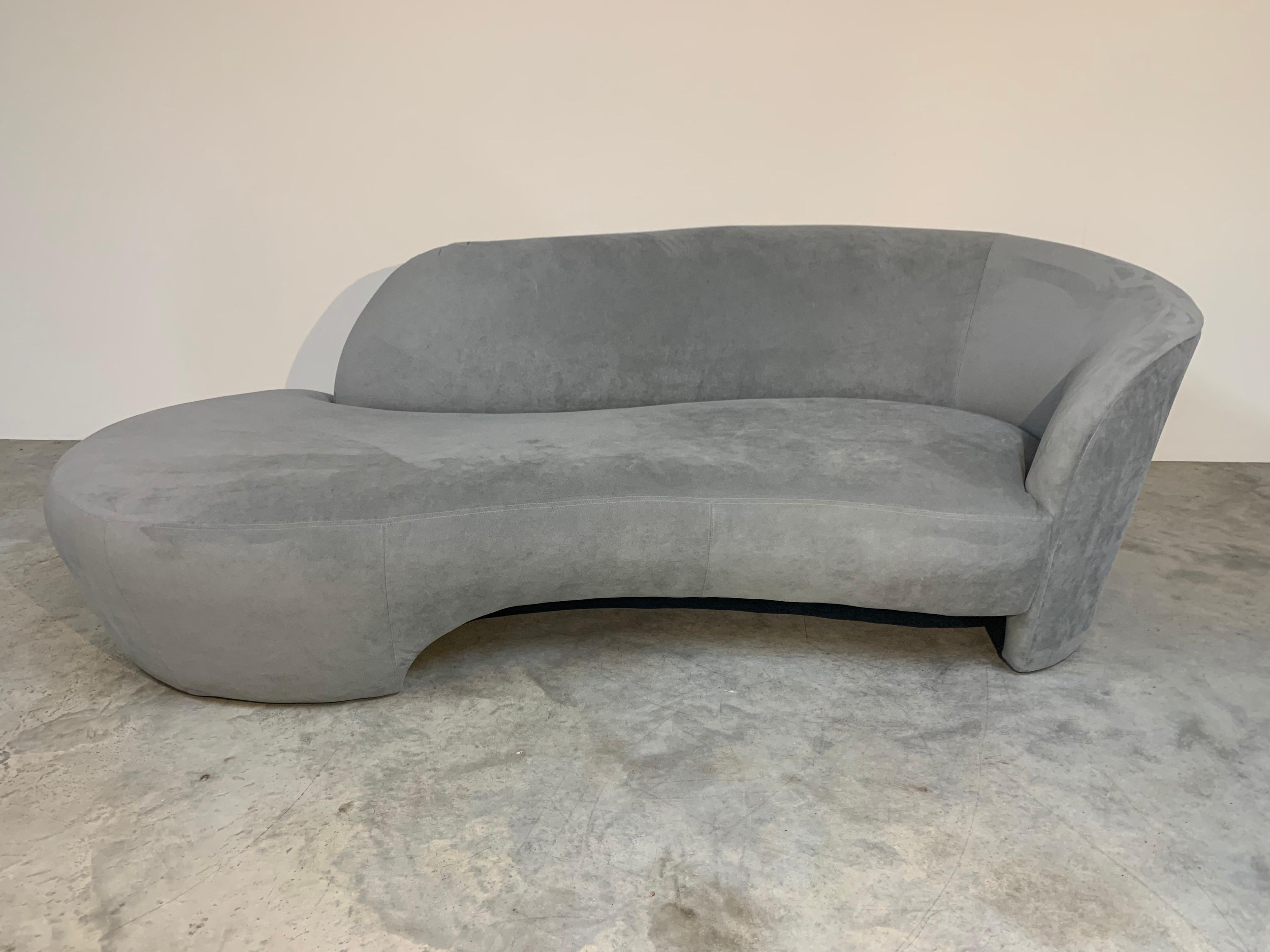 A beautiful light grey/blue utrasuede chaise lounge sofa by Weiman Preview after Vladimir Kagan with matching ottoman pouf. Ottoman is on casters.
Note: We have a matching pair of these sofas available. Both with ottomans. Sold separately. 
Both are