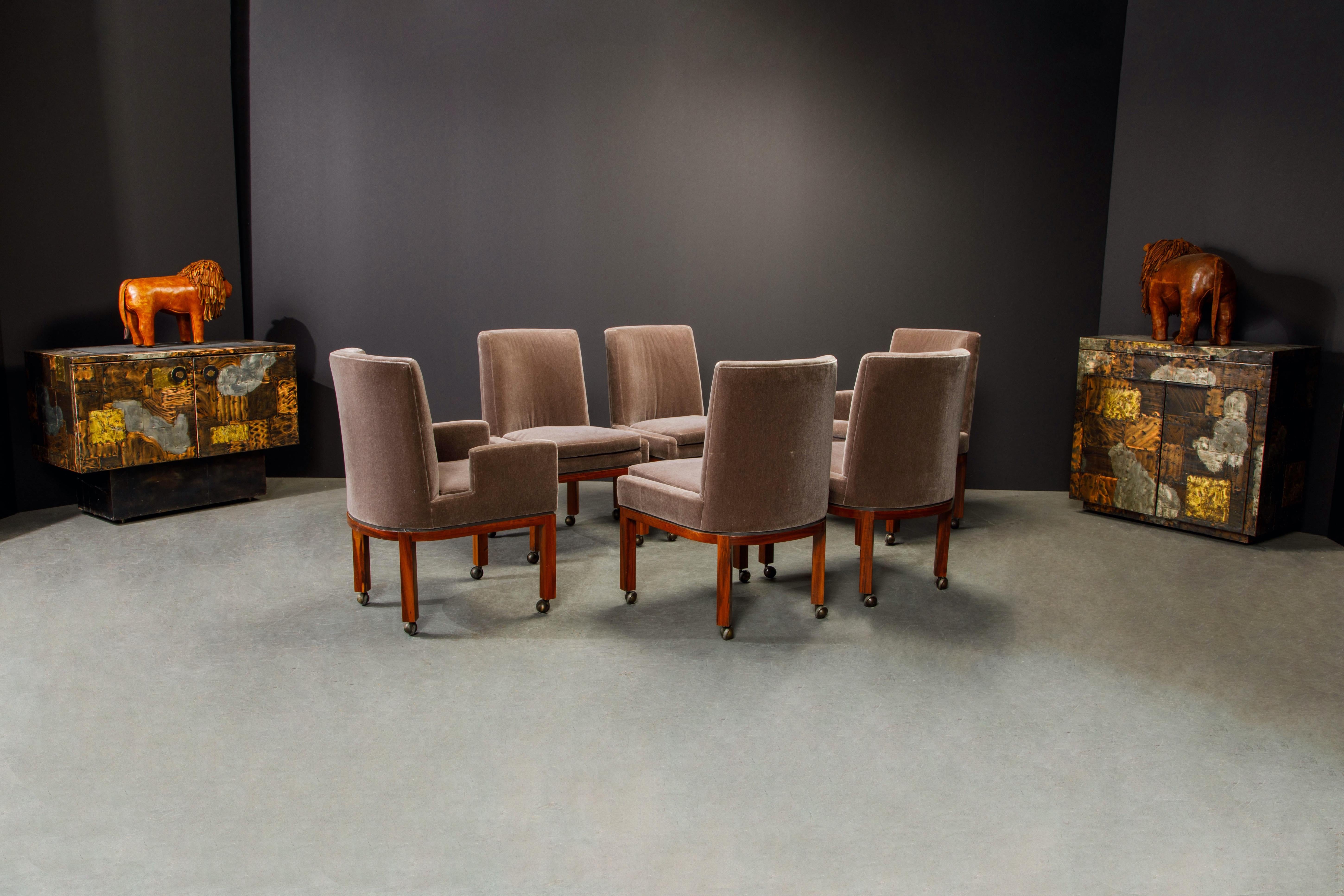 A beautiful set of signed Vladimir Kagan for Vladimir Kagan Designs dining chairs, comprised of two handmade armchairs and four side chairs, and featuring its original brownish grey / grayish brown mohair fabric, walnut frames and on casters which