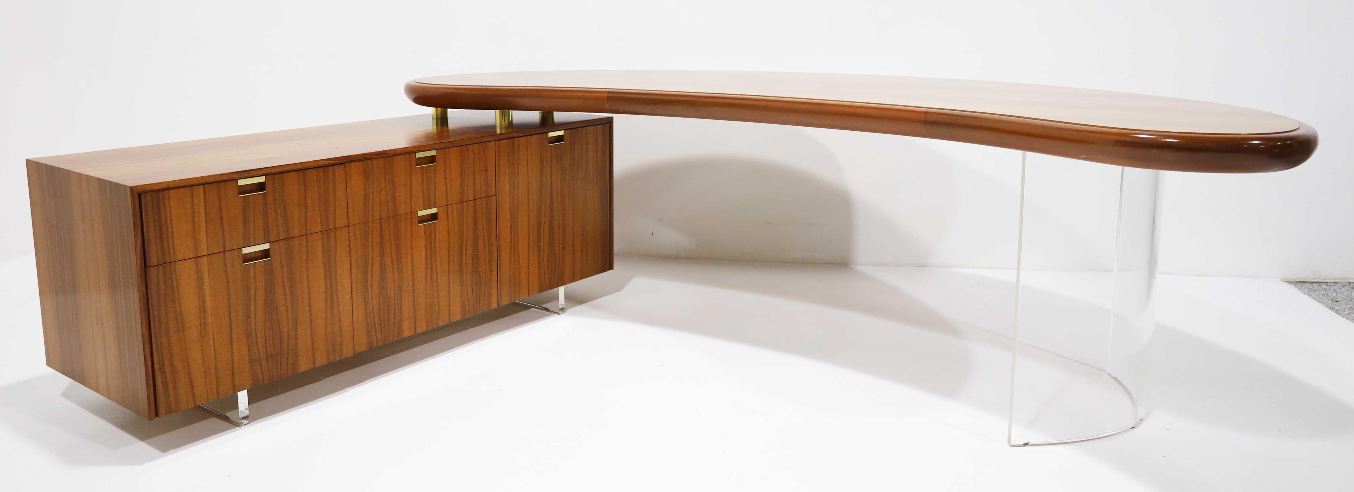 Questa è davvero una scrivania eccezionale, progettata e realizzata da Vladimir Kagan. La scrivania presenta un'area di lavoro a forma di rene sostenuta da una spessa base in lucite e una credenza abbinata, il tutto composto da un esotico legno di