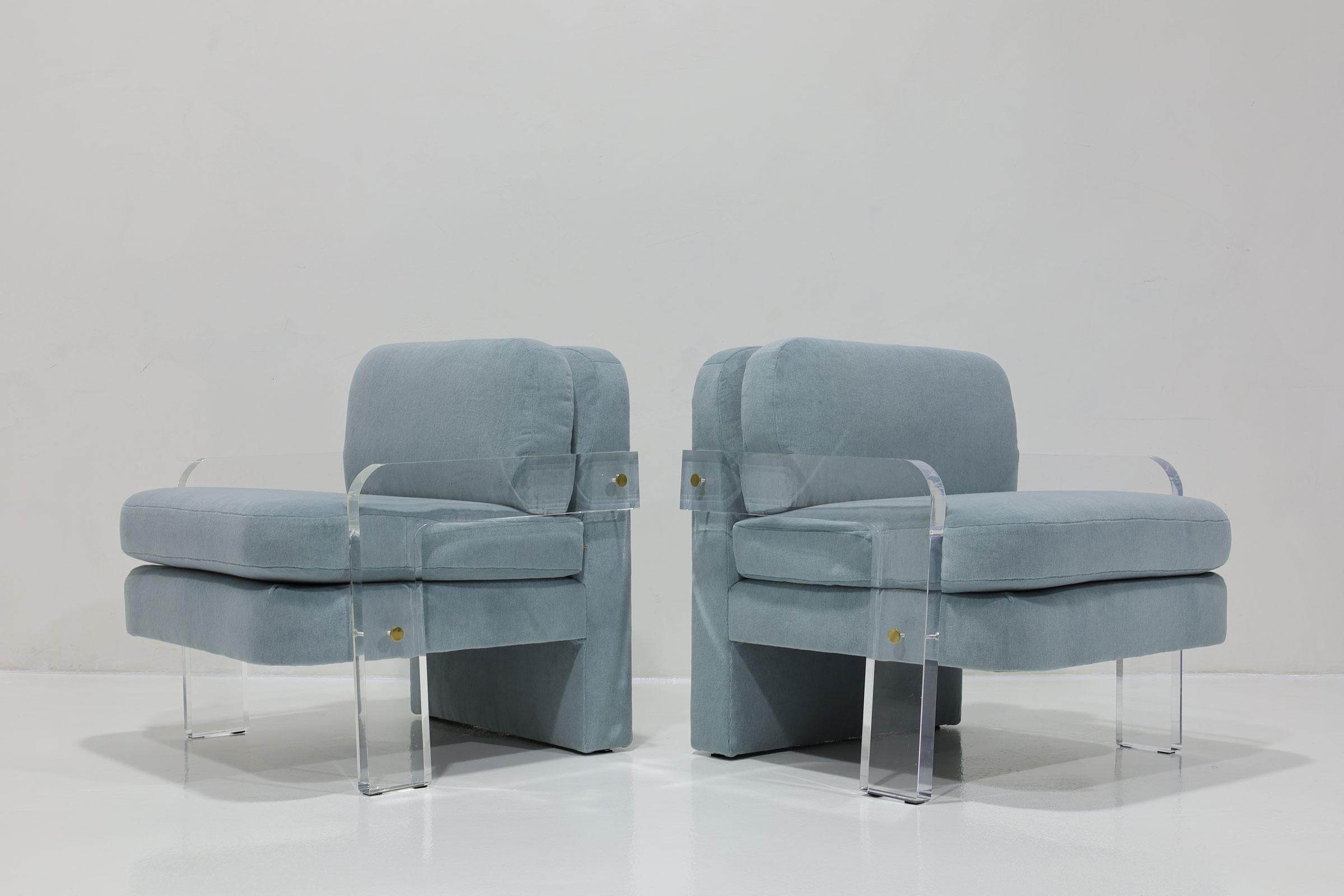 These are a pair of hard-to-find Vladimir Kagan lucite framed lounge chairs. Chairs have brass trim and we have restored by professionally polishing the lucite frames and upholstering in Holly Hunt Great Plains Alpaca in a soft blue. The chairs are