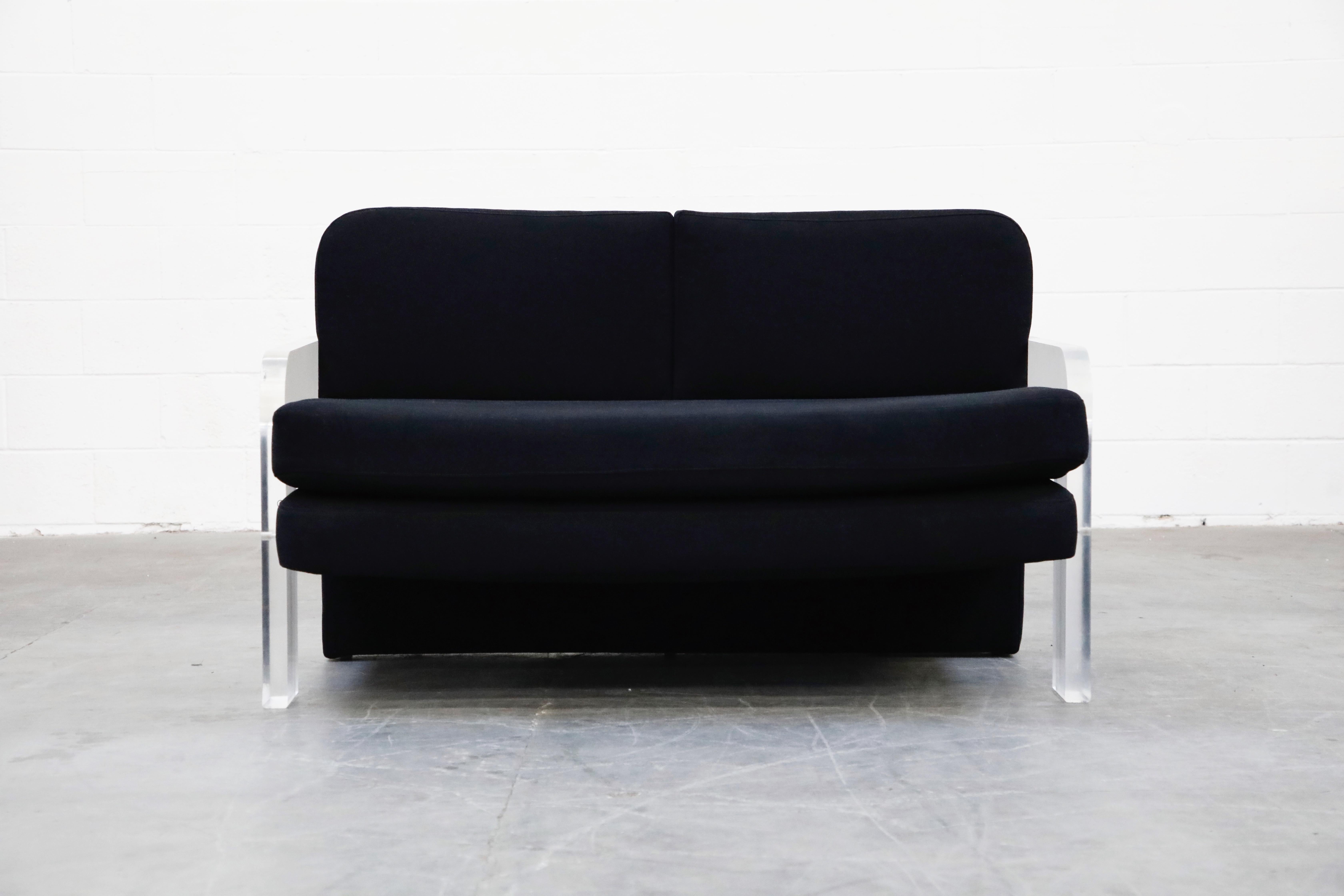 A stylish and Classic Vladimir Kagan settee with Lucite arms and legs and black fabric upholstery. This circa 1970s loveseat sofa is rare collectors piece, while also a comfortable and stylish addition to your interior design project. The