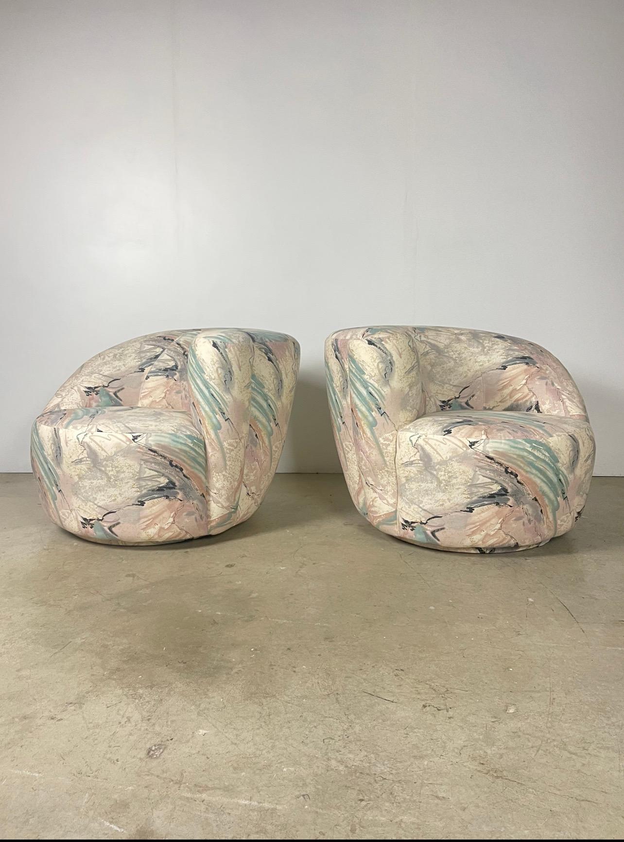 Up for sale is a pair of Nautilus chairs attributed to Vladimir Kagan, one of his most iconic designs. These chairs feature a unique curved shell shape that is both stylish and comfortable, with a plush padded seat and backrest. The chairs are