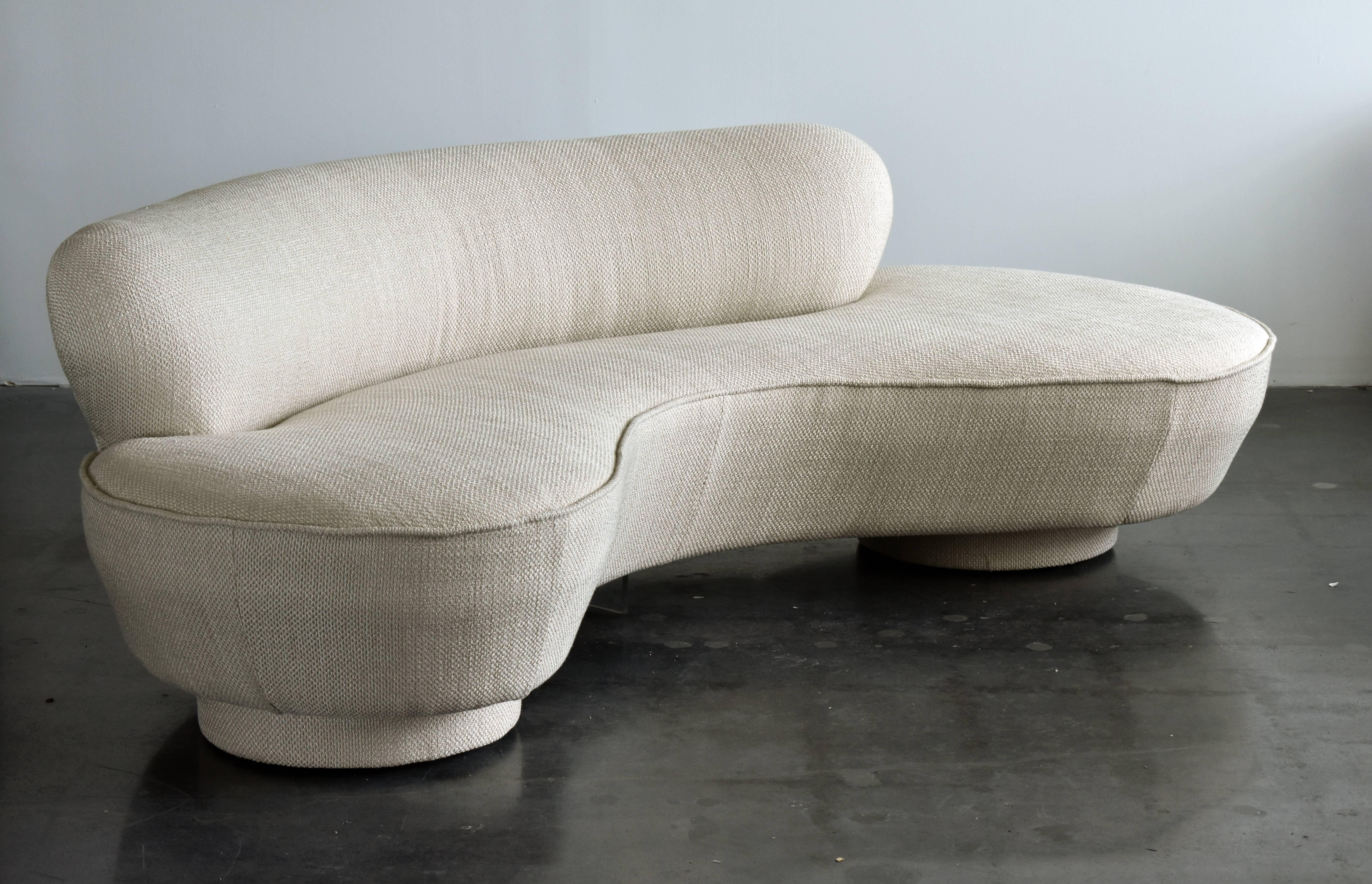A curved sofa by Vladimir Kagan. Upholstered in new light grey high end chenille fabric. Form referencing the early organic design movement. Executed by Directional.

Other American designers of the era include Edward Wormley, Philip & Kelvin