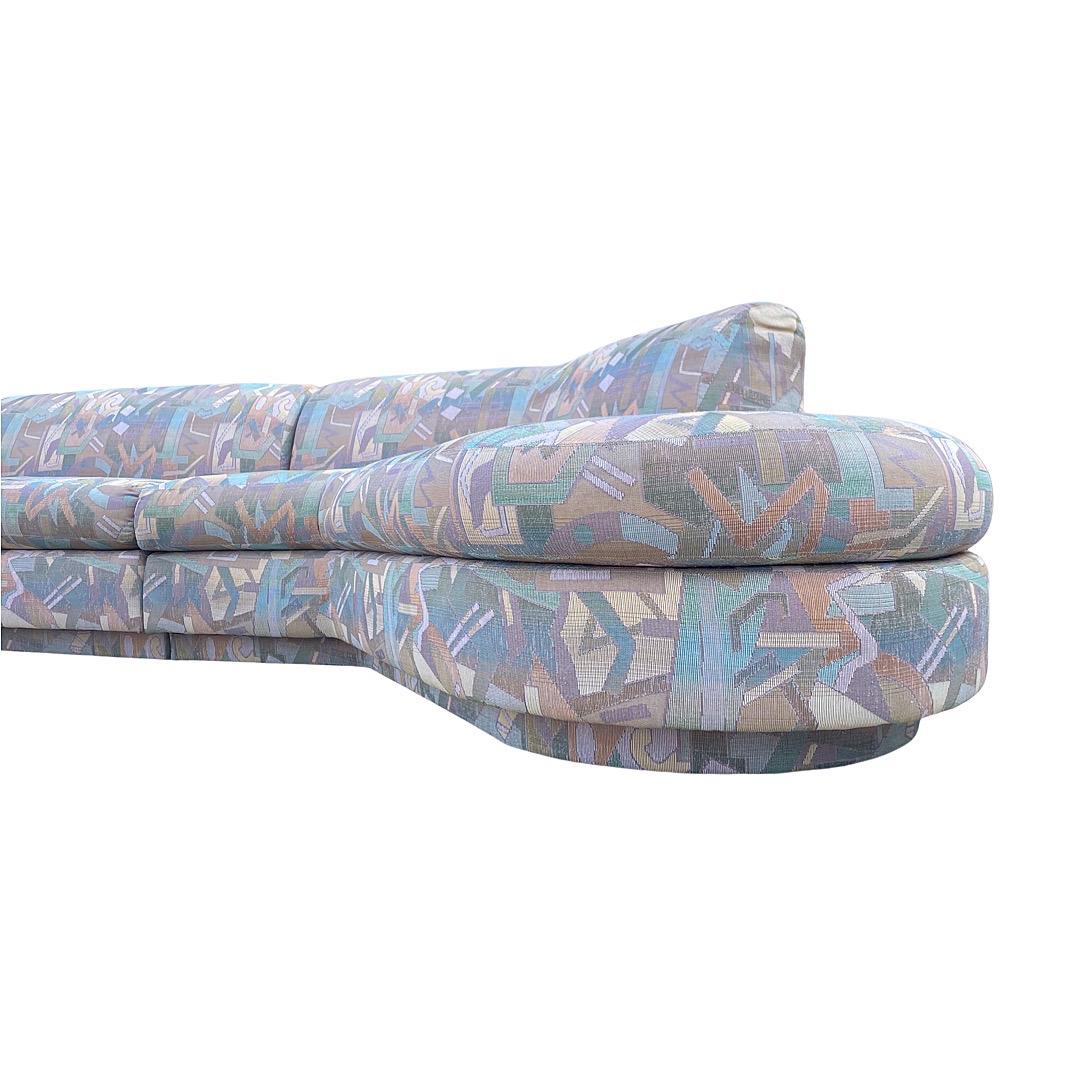 Post modern biomorphic two piece custom sectional sofa by Directional in the style of Kagan and Baughman. Original pastel and muted earth tone Memphis style upholstery. Seating rests on an upholstered plinth base. This sofa came out of a large high