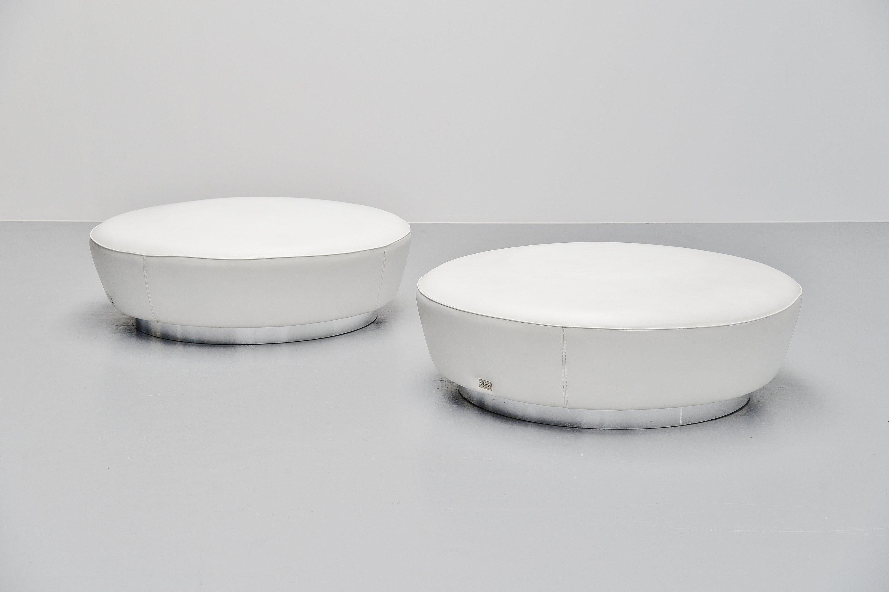 Super nice and large seating poufs designed by Vladimir Kagan and manufactured by Directional, United States, 1999. The stools have white leather upholstery and have a chrome ring at the bottom. These poofs are often sold with the serpentine sofa by