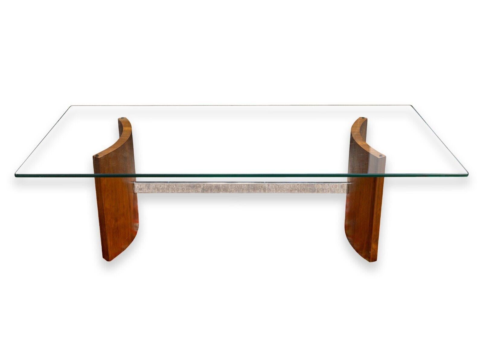 A Vladimir Kagan Propeller glass coffee table. A fantastic mid cenruty modern table with great design, great materials, and a great name in Vladimir Kagan. This piece features a rounded rectangular glass table top, two curved wooden legs, and a
