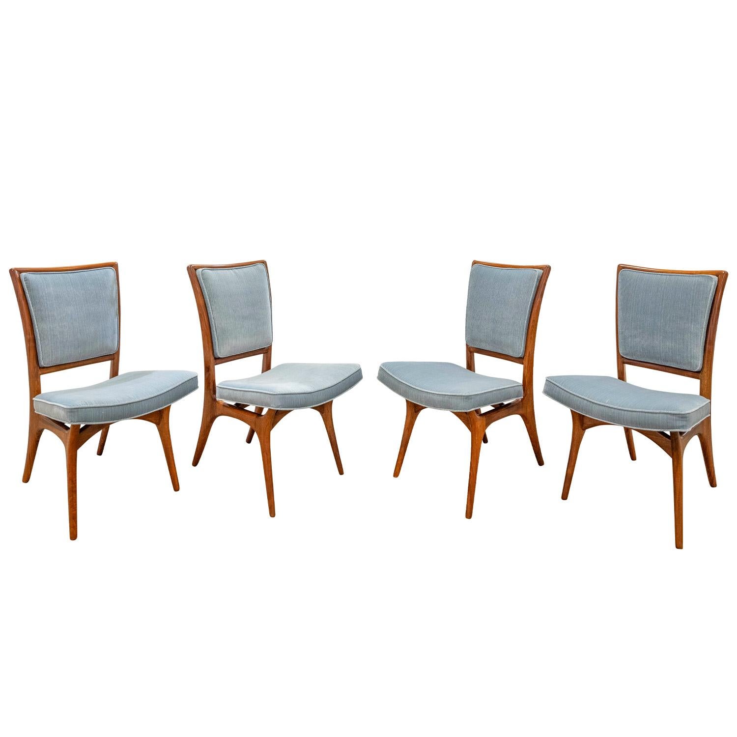 Set of 4 iconic and rare dining/game chairs model  175A in sculpted walnut with upholstered seats and backs by Vladimir Kagan, American 1950's.  These stunning chairs have been refinished and newly upholstered in light blue velvet.  They are