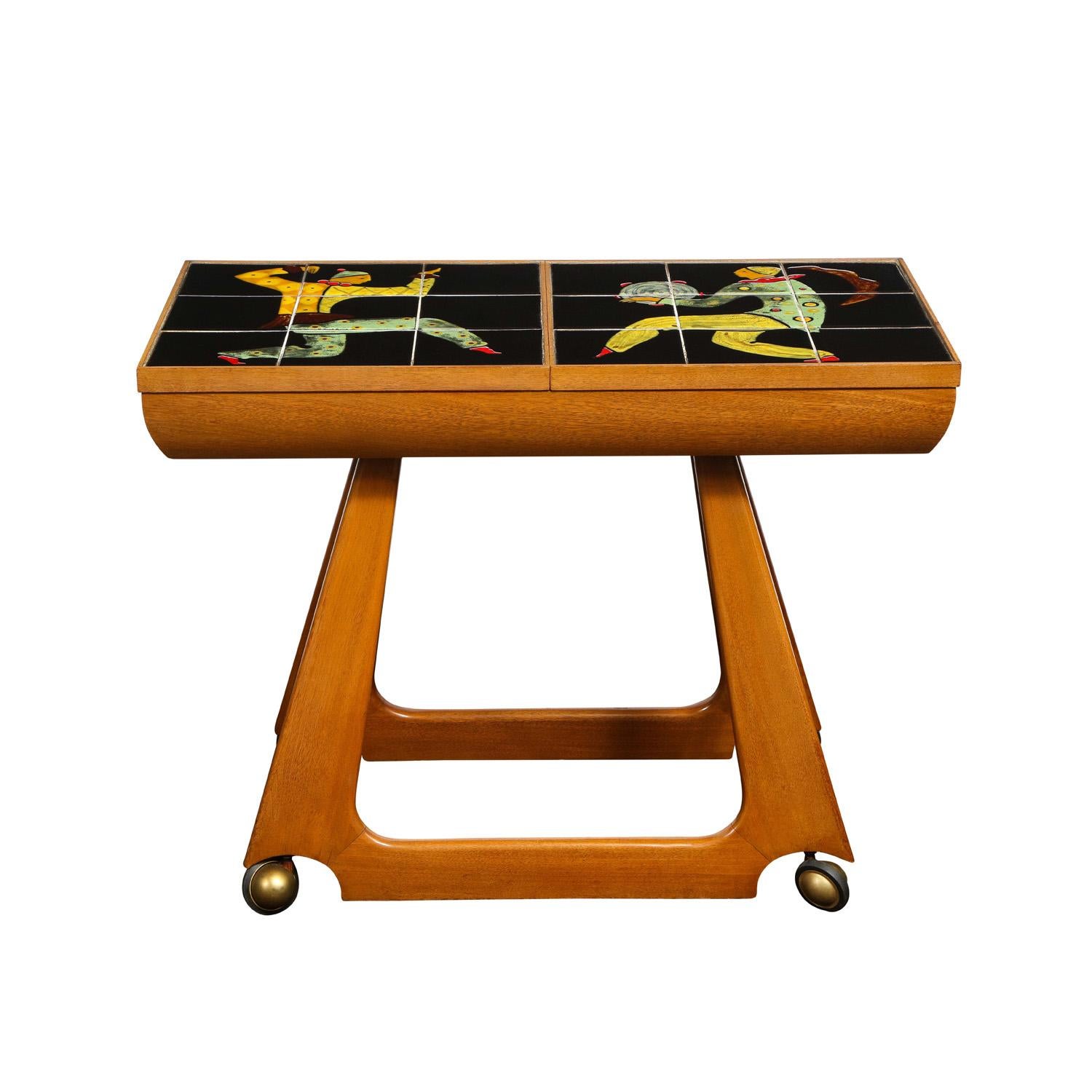 Rare and important serving cart on castors in walnut with retractable top incorporating inset hand-thrown ceramic tiles showing posed dancers by Alexandra Kasuba for Vladimir Kagan, American 1950. Kasuba did unique hand-thrown tiles with exuberant