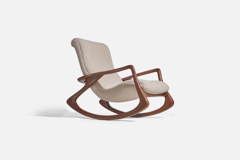 A rocking lounge chair designed by Vladimir Kagan for his own firm Vladimir Kagan Designs Inc. Designed c. 1950s, produced c. 1970s.

Features finely carved walnut, reupholstered in a brand-new high-end bouclé fabric.

