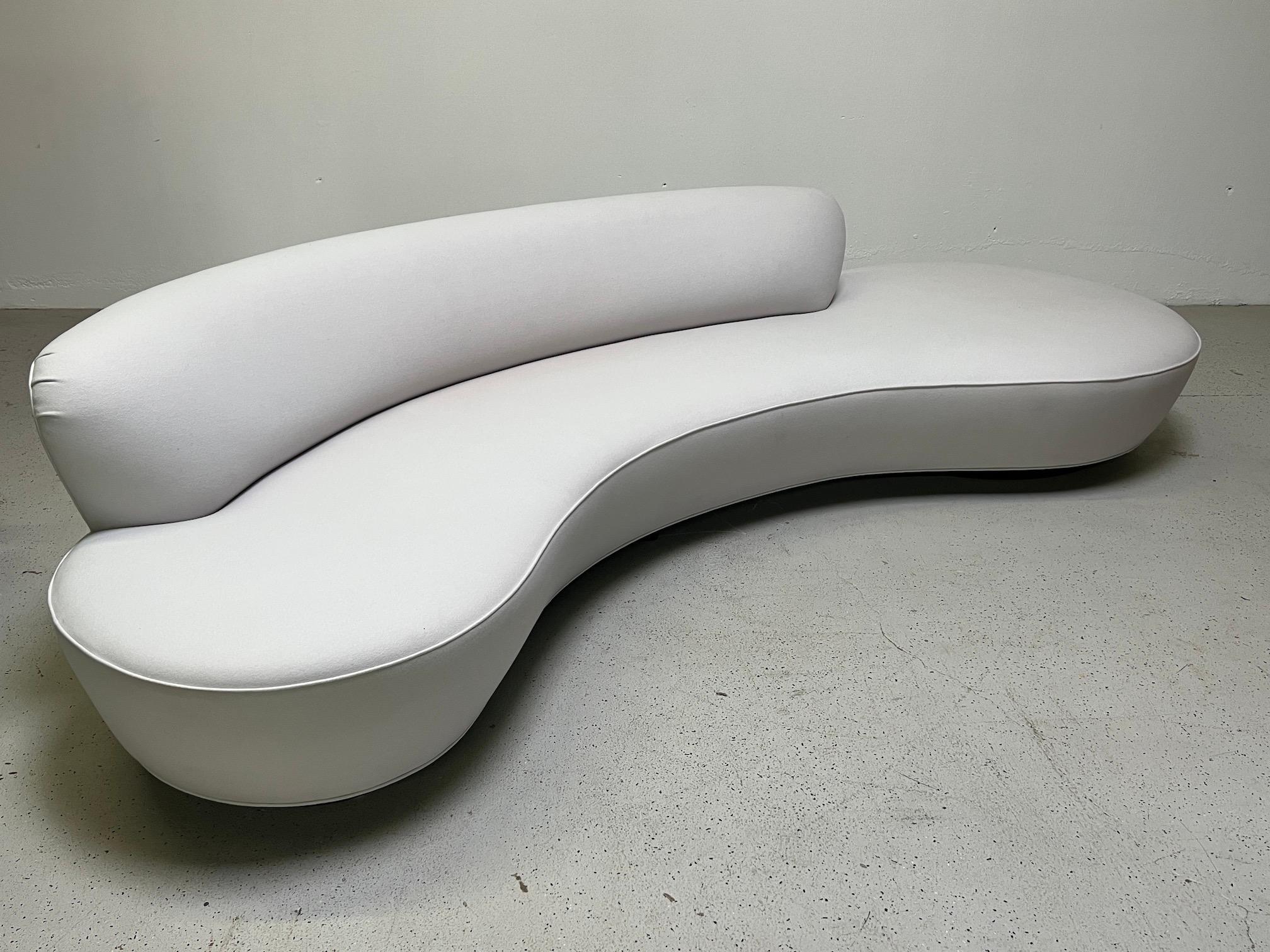 A large and iconic serpentine sofa designed by Vladimir Kagan. This sofa was purchased from Kagan about a decade ago and upholstered in a heathered light grey Holly Hunt cashmere fabric. Signed with Kagan plaque to bottom.