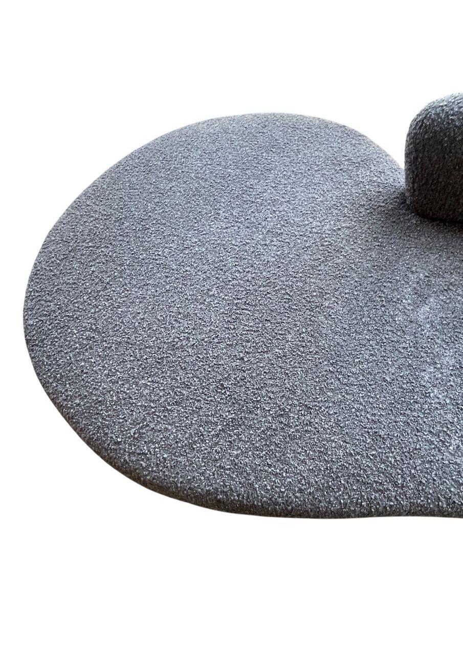 An iconic Serpentine Sofa by Vladimir Kagan, showcasing the designer’s signature curvilinear form and sculptural presence. Upholstered in a luxurious charcoal black fabric and brass details, this statement piece exemplifies mid-century modern