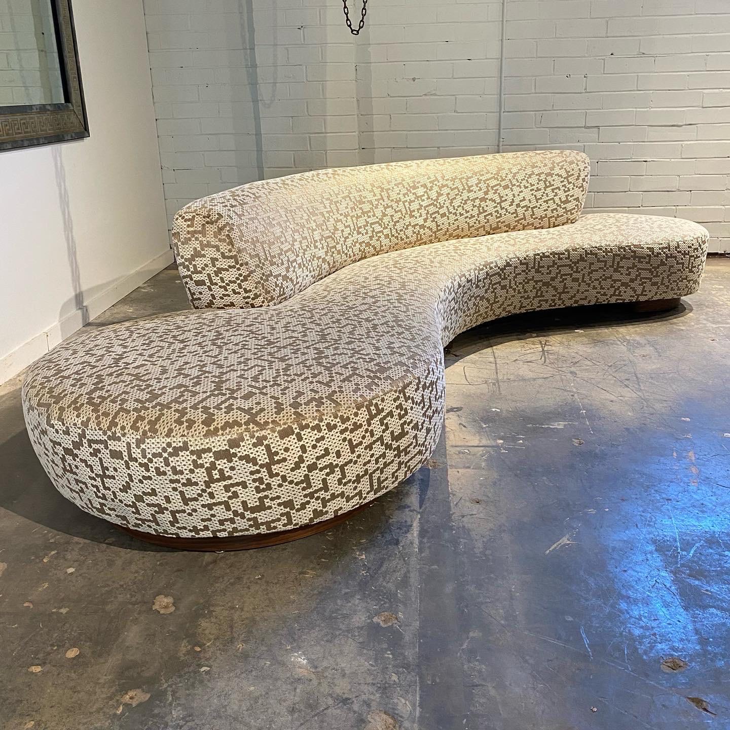 An incredible serpentine sofa from Vladimir Kagan designed in 1950. This example was originally upholstered in white leather with white lacquer bases, circa 2000. 
Now restored in a luxurious layered fabric of chenille with a handsome ground weave