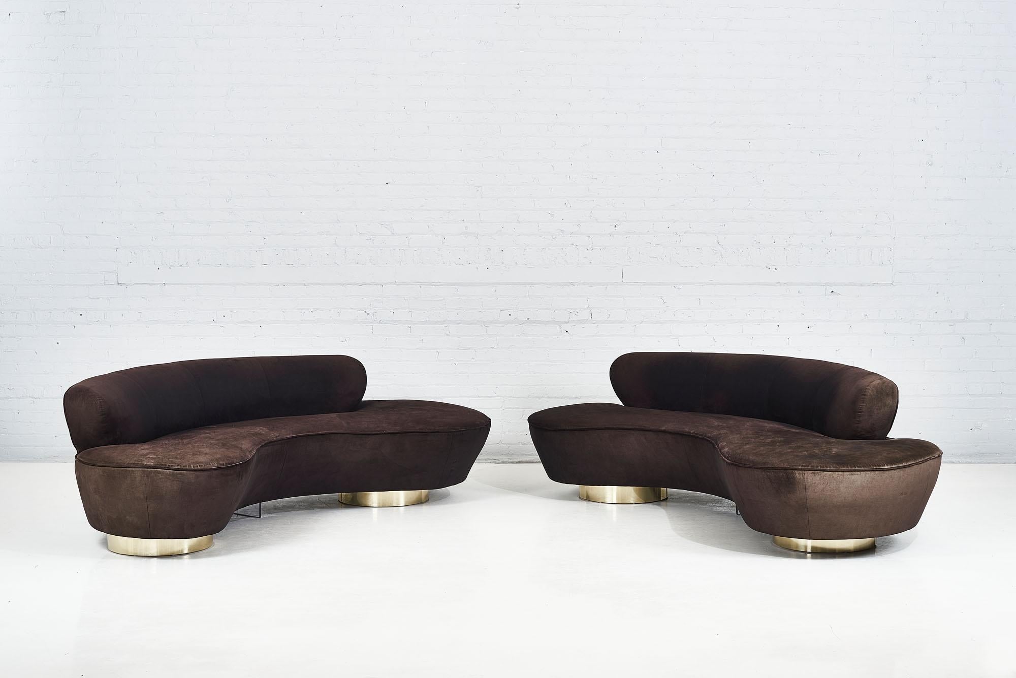 Pair of serpentine sofas designed by Vladimir Kagan for Directional Furniture. Original brown micro velvet upholstery over brass bases. Original fabric shows minor wear and fading. Both sofas retain original Directional labels.

Priced