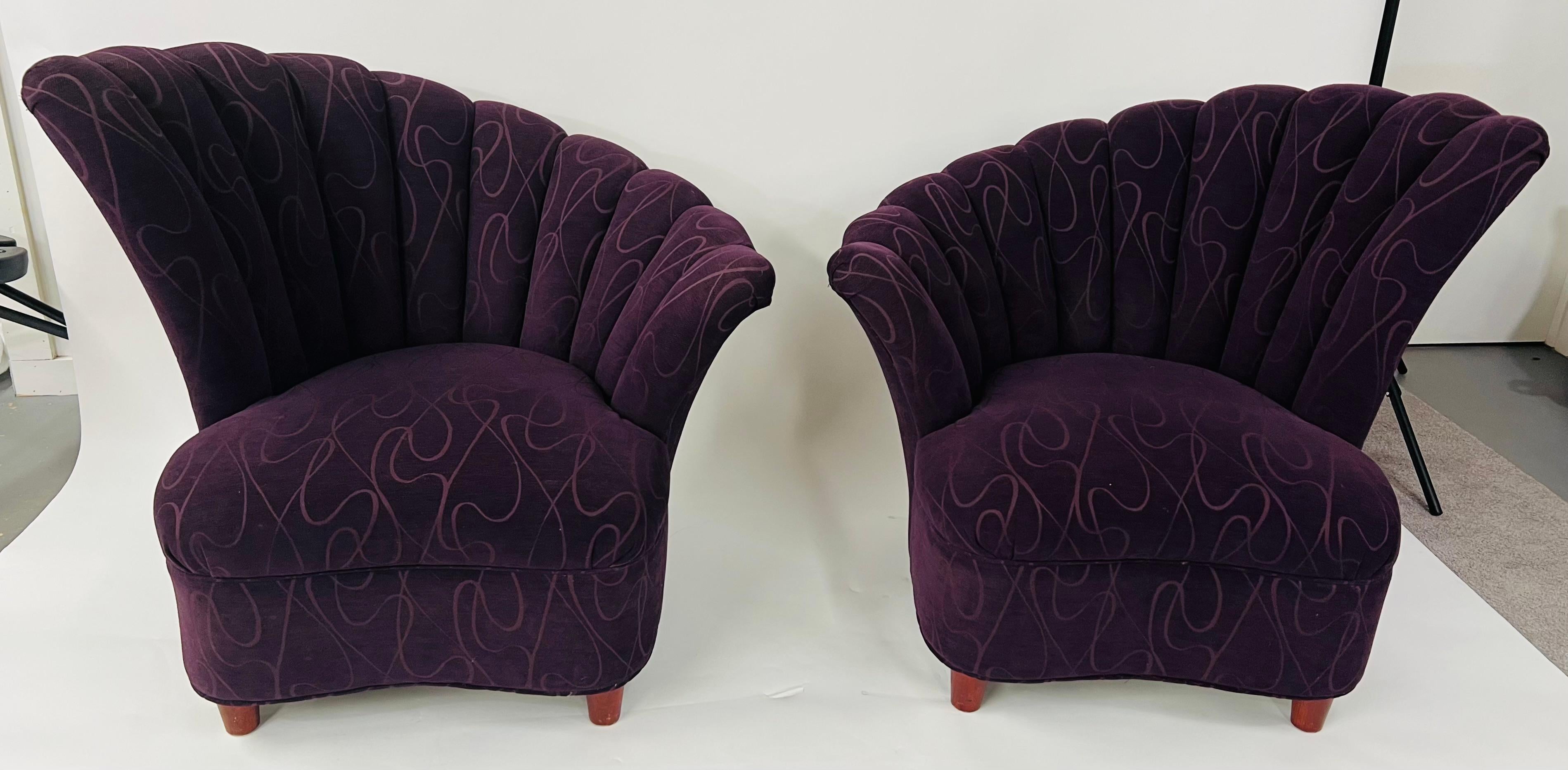 A timeless pair of Mid-Century Modern lounge chairs featuring a scalloped design fan backrest. The chairs upholstery is in a dark purple, very fashionable color, and embellished with an amazing pattern adding style and elegance to the chairs. The