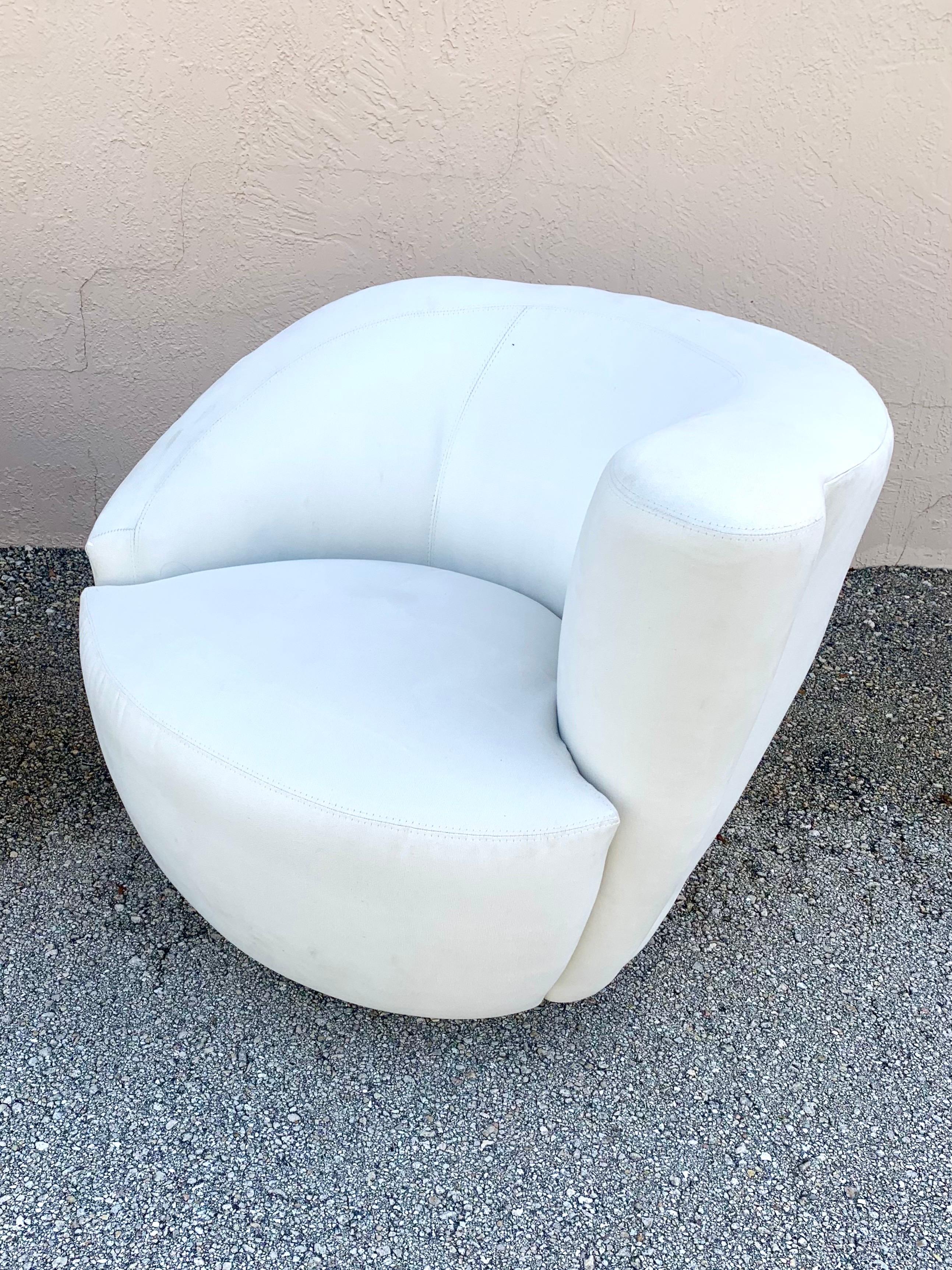 Pair of Mid-Century Modern style Nautilus swivel chairs. Gorgeous form and amazingly comfortable. Upholstery and foam are in great condition. Upholstery has a soft suede like feel to it. Chairs are not marked. No rips or stains. Upholstered bases.