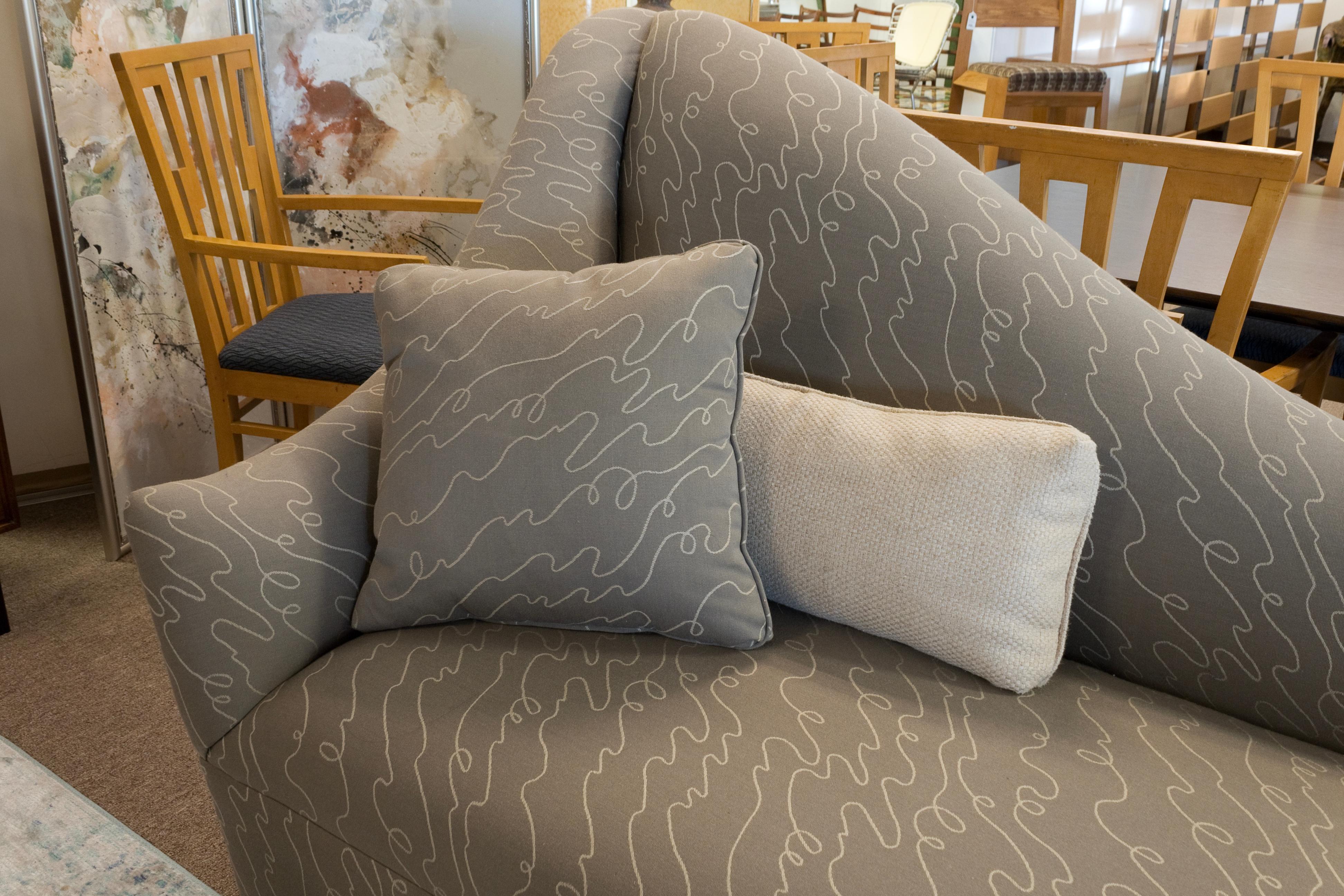 Un sofá chaise lounge asimétrico de estilo Vladimir Kagan. Este precioso sofá presenta un diseño de chaise izquierda con un tapizado de estampado abstracto gris de la cabeza a los pies. Esta pieza tiene una maravillosa silueta fluida, con un