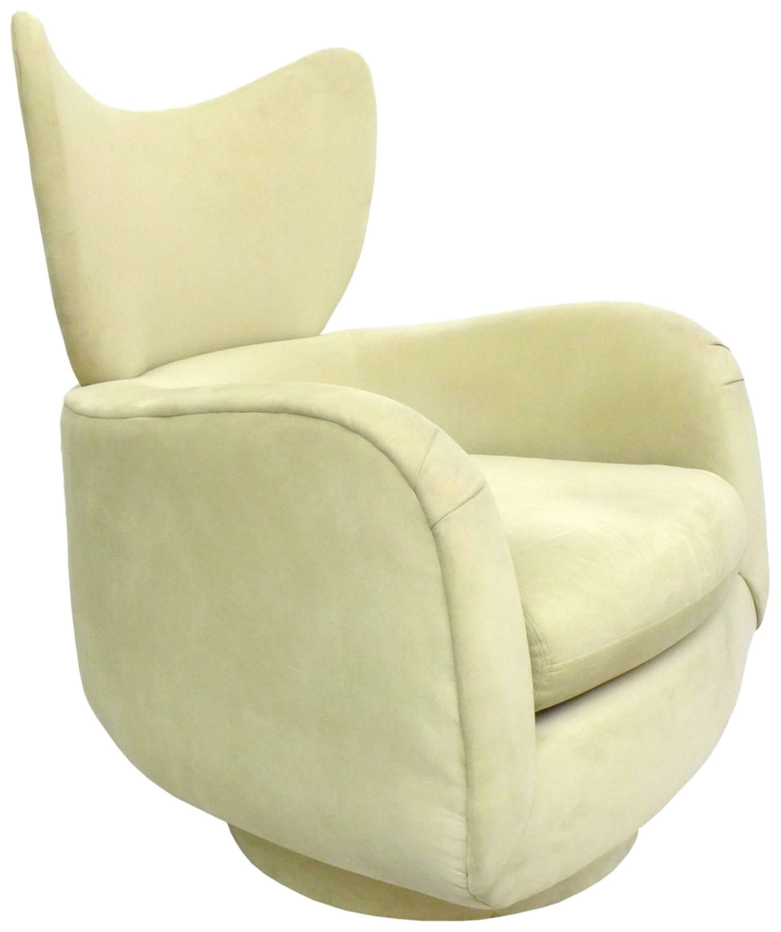 An incredibly stylish and comfortable swivel lounge chair designed by Vladimir Kagan for Directional. A great form with an unusual wing-back detail and its original pale-sage suede upholstery. A wonderfully sculptural and functional seating design