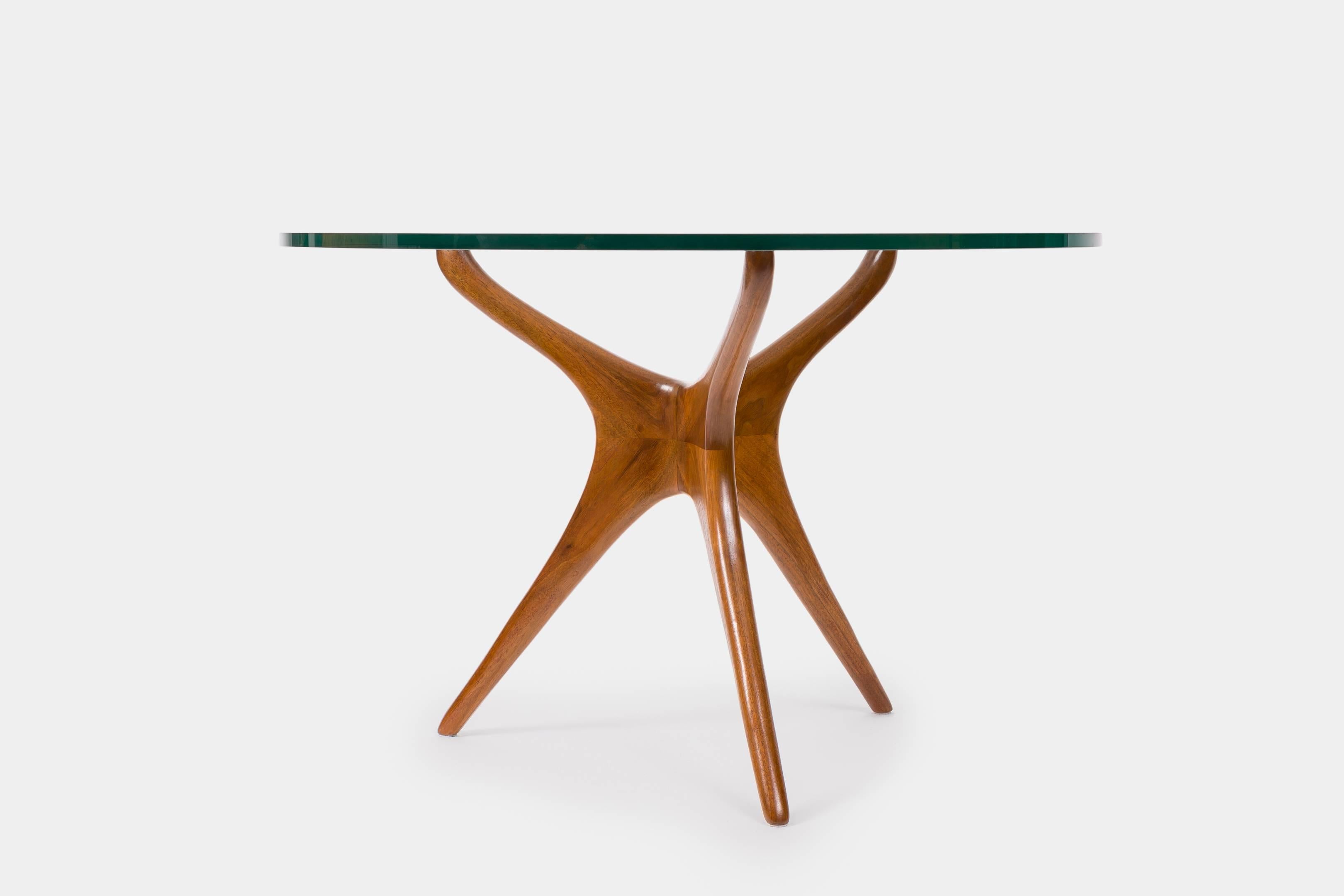 Vladimir Kagan dining or center table with organic, sculptural walnut tripod base suspending original thick plate glass top from the late 1960s to mid-1970s, USA.

Literature:
Vladimir Kagan, Complete Kagan: A Lifetime of Avant-Garde Design, New