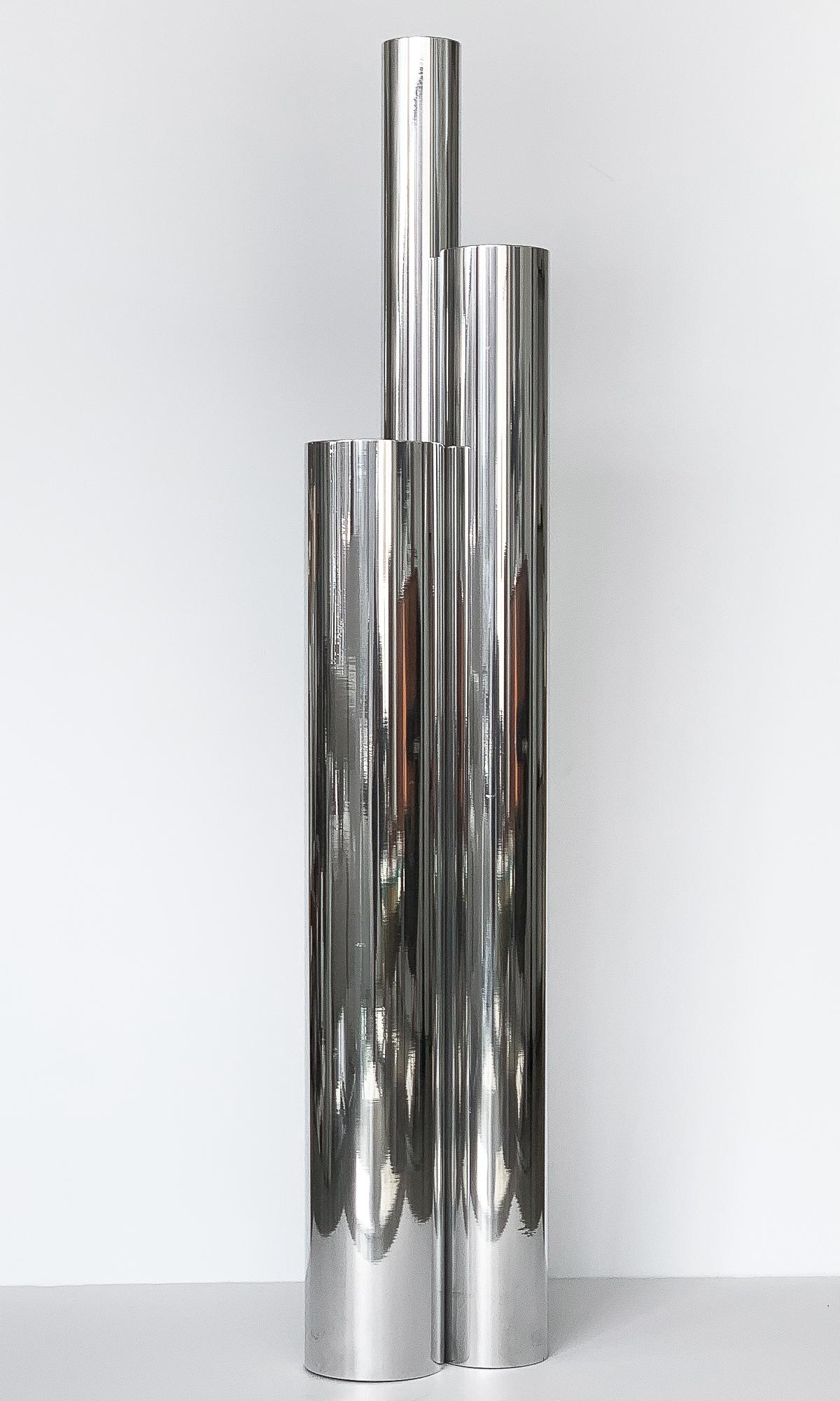 Tubular polished aluminum skyscraper floor lamp, circa 1960s. Three mirror polished aluminum tubes of varying heights, matte black interior, each with a recessed light. Takes 3 standard base light bulbs. In-line on/off pedal floor switch. Working