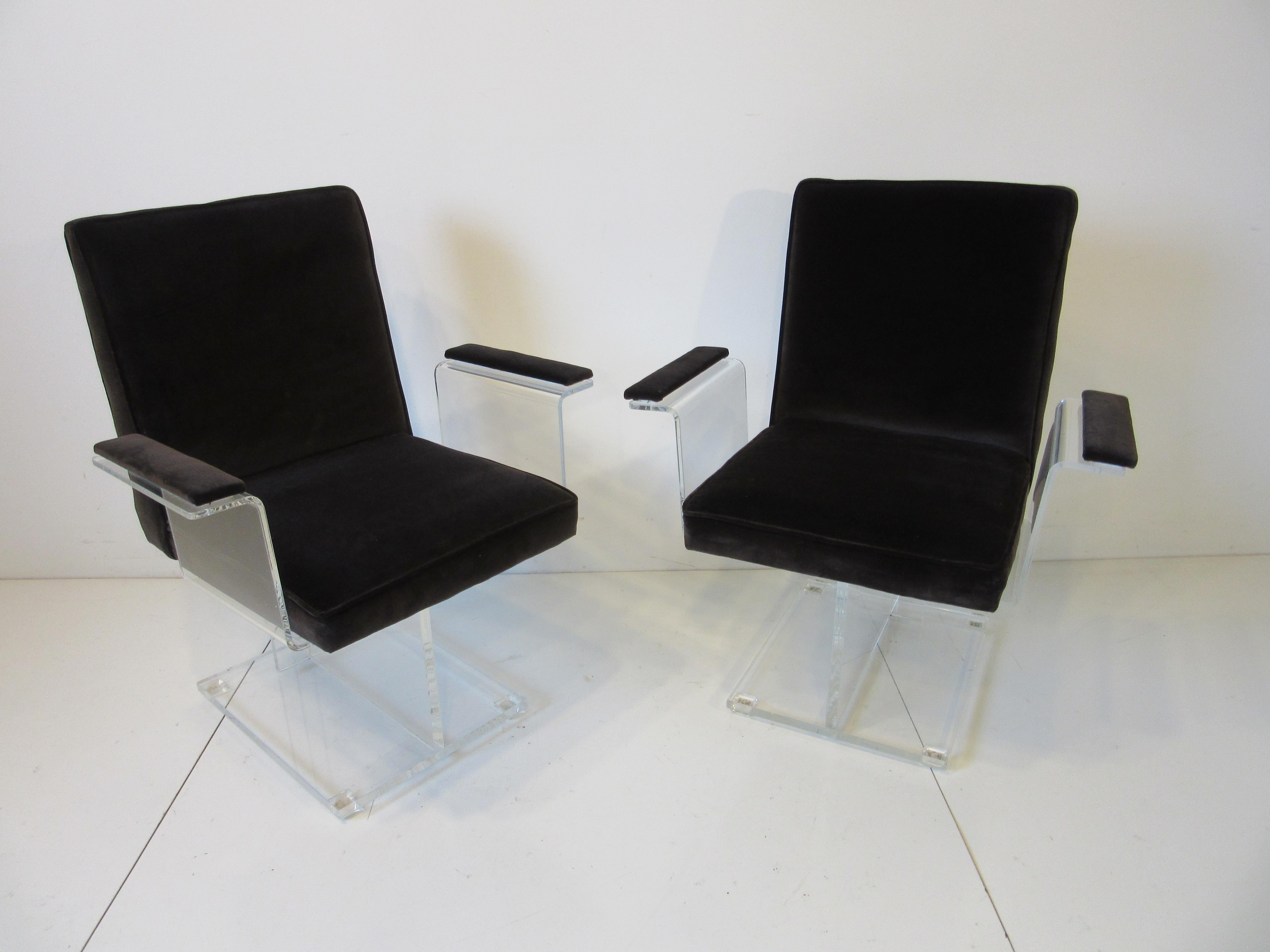 A pair of Kagan Lucite pedestal armchairs upholstered in a dark chocolate velvet fabric having a great sculptural look with matching arm rests. Small Lucite foot pads attached to the square base help protect your floors, a rare form manufactured by