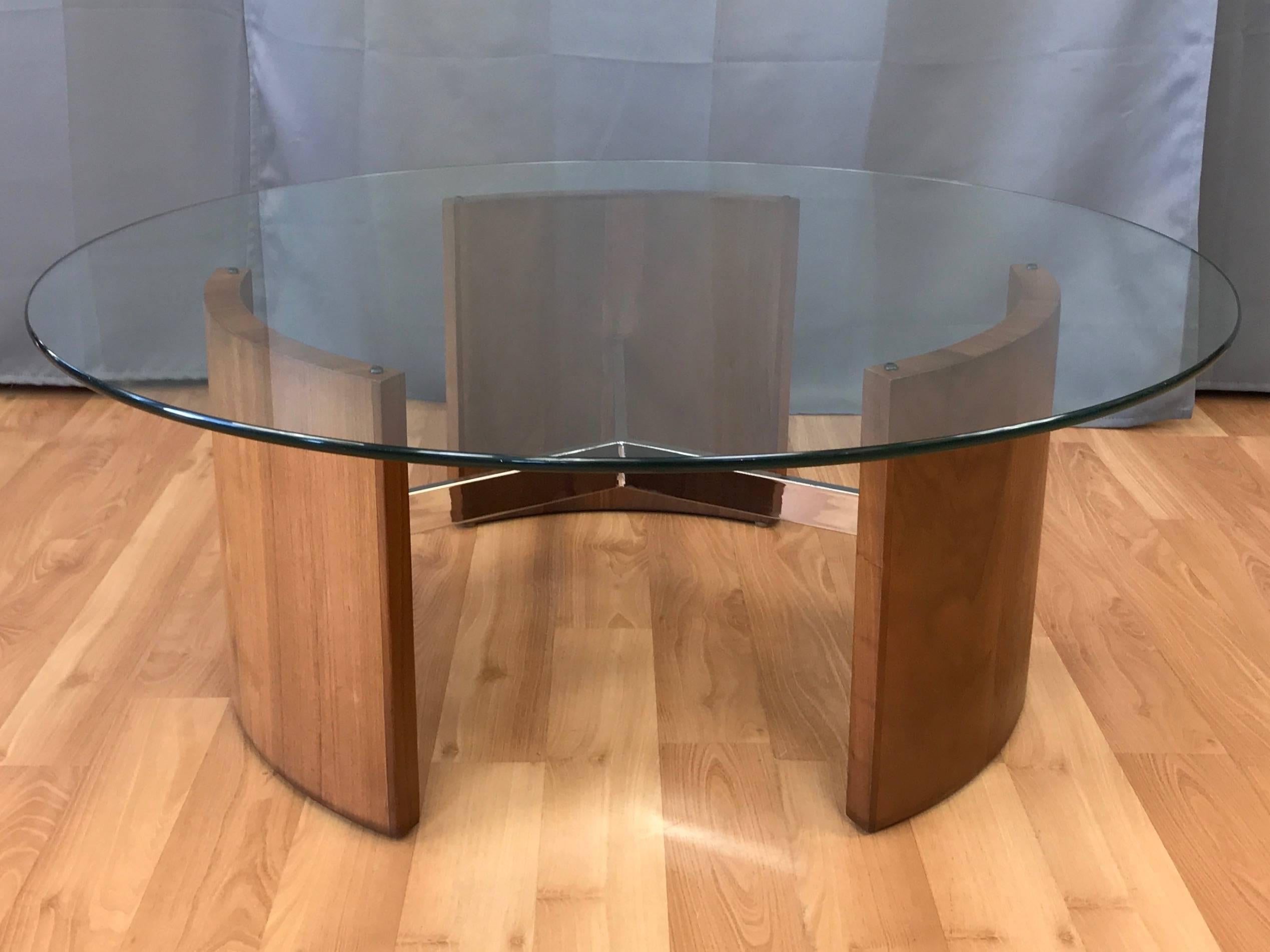 A striking Mid-Century Modern walnut and polished metal Radius coffee table by Vladimir Kagan.

Architecturally sculptural design comprised of three thick, curved walnut slabs joined by a polished nickel-plated steel three-spoke center. Geometry of