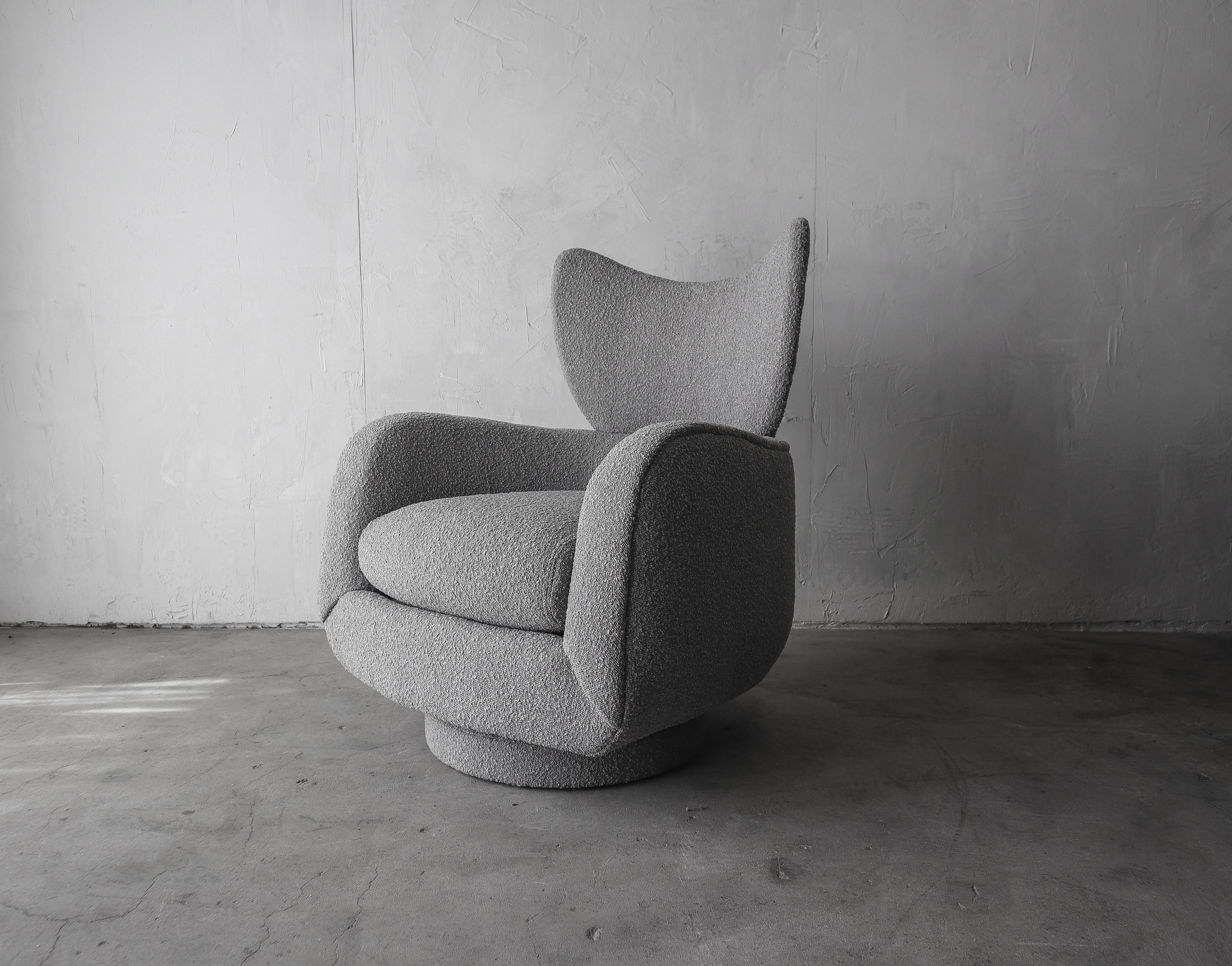 Iconic Vladimir Kagan for Directional wingback tilt and swivel lounge chair with matching ottoman. Both the chair and ottoman are newly reupholstered in gray bouclé fabric. The chair is comfortable yet sculptural, its furniture and also art. The