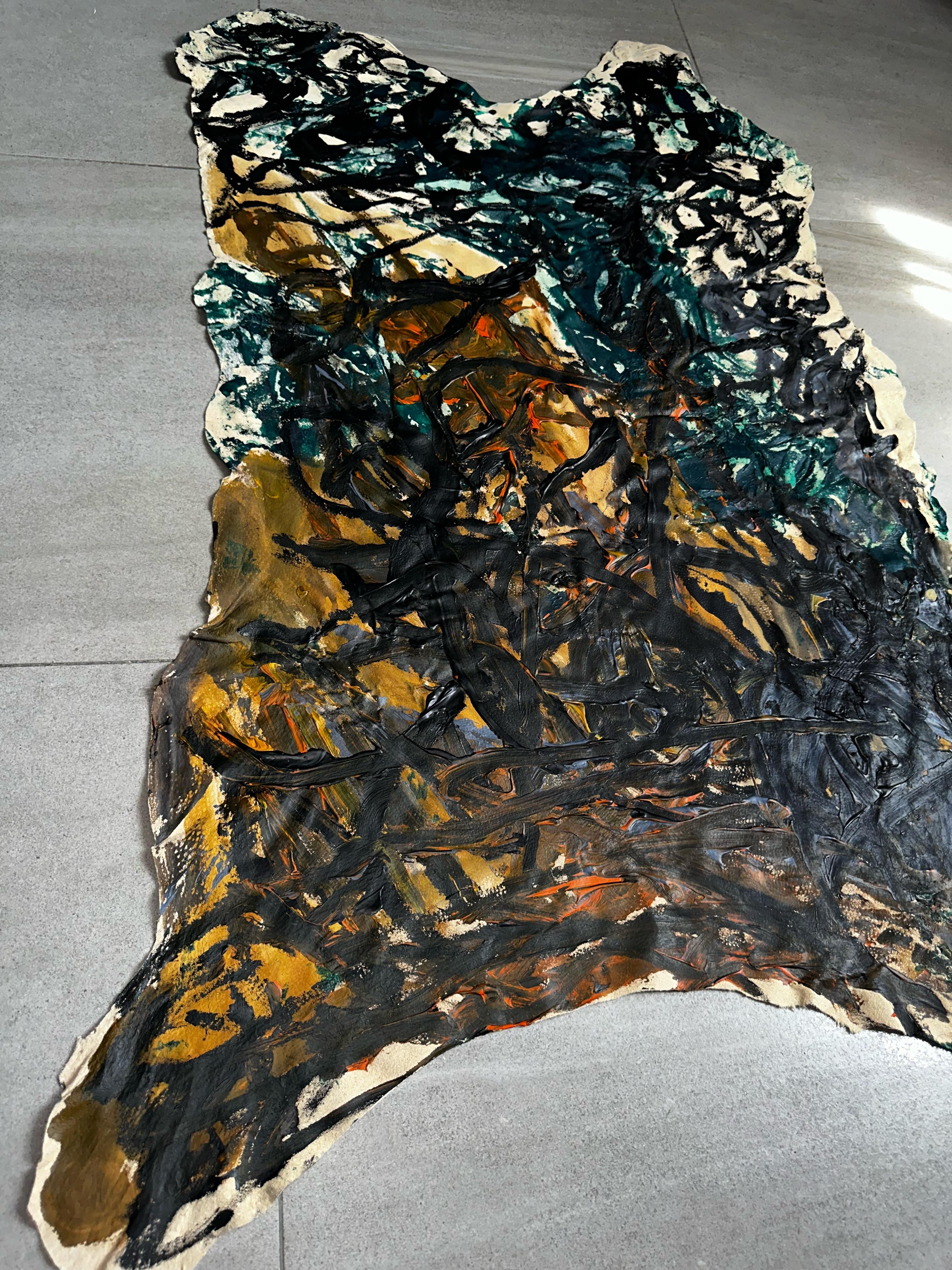 Primitive black strokes, wild and chaotic, pierce through the light natural leather, creating an atmosphere of ancient mysteries. Green accents add depth, conveying the essence of the emergence of life and the everyday existence of ancient people.