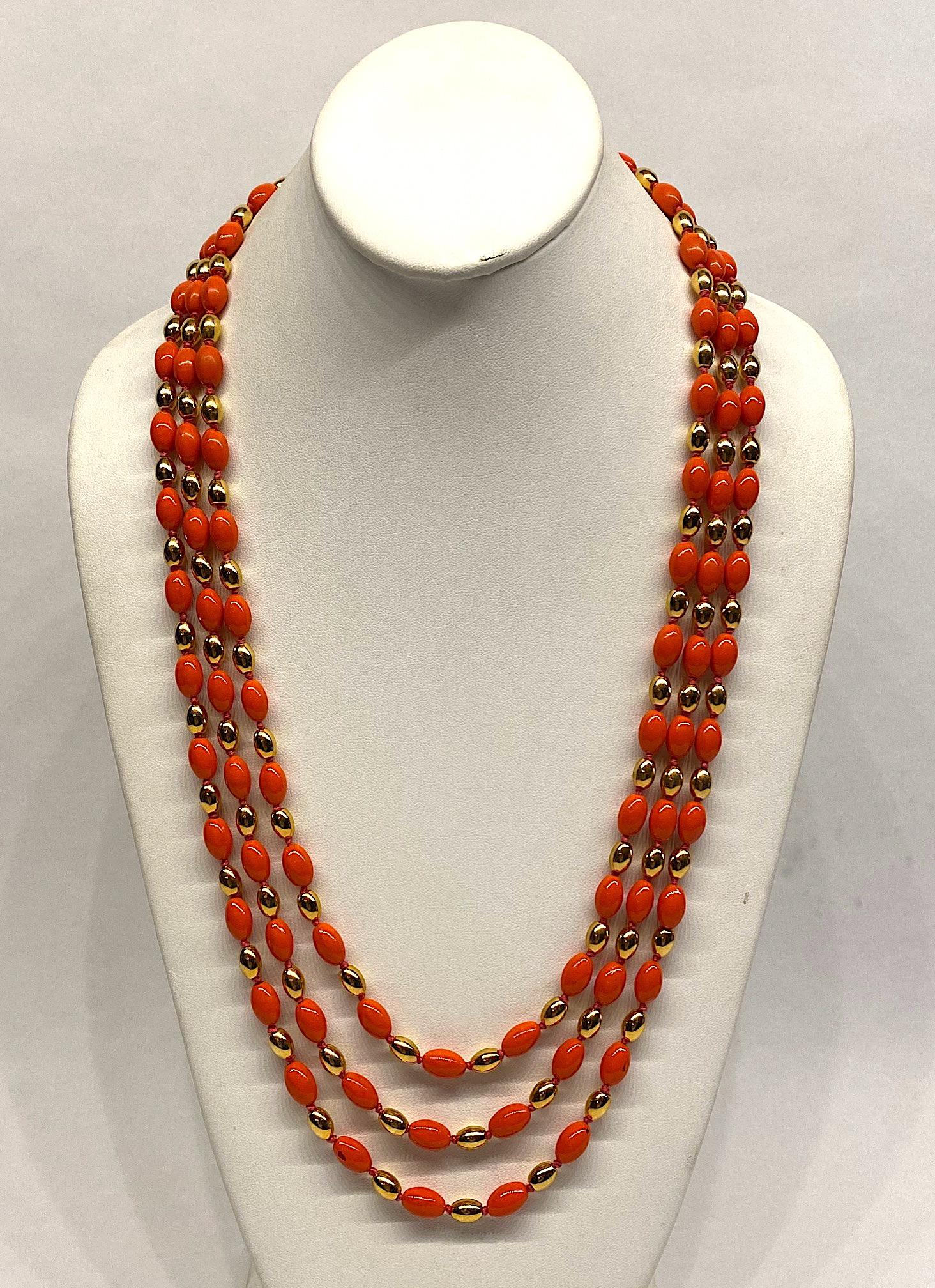 An elegant graduated bead necklace by Italian fashion jewelry company Vogue Bijoux. The stylized letter type on the clasp and orange color date the necklace to the late 1970s to mid 1980s. The three strands are comprised of individually knotted