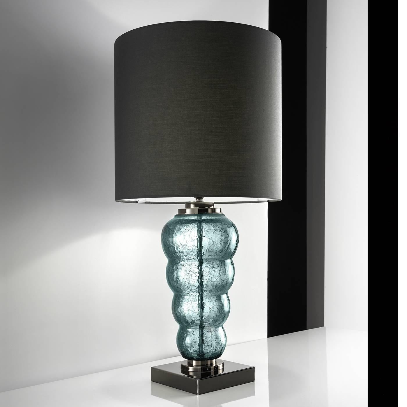 Stacked, handblown glass globes create the alluring aesthetic of this elegant table lamp. The square metal base with black finish supports the sinuous body of the mouth-blown viridian Murano glass with a crackle finish, framed at both ends with a