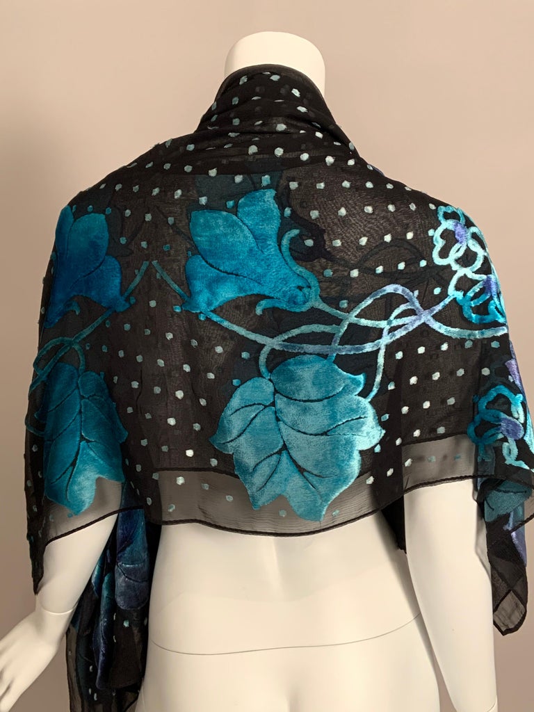 This beautiful shawl has a delicate black silk chiffon base with gorgeous blue shaded to lavender flowers around the border and small blue velvet dots adding a touch of whimsy to the center.  One size fits all and the shawl is in excellent