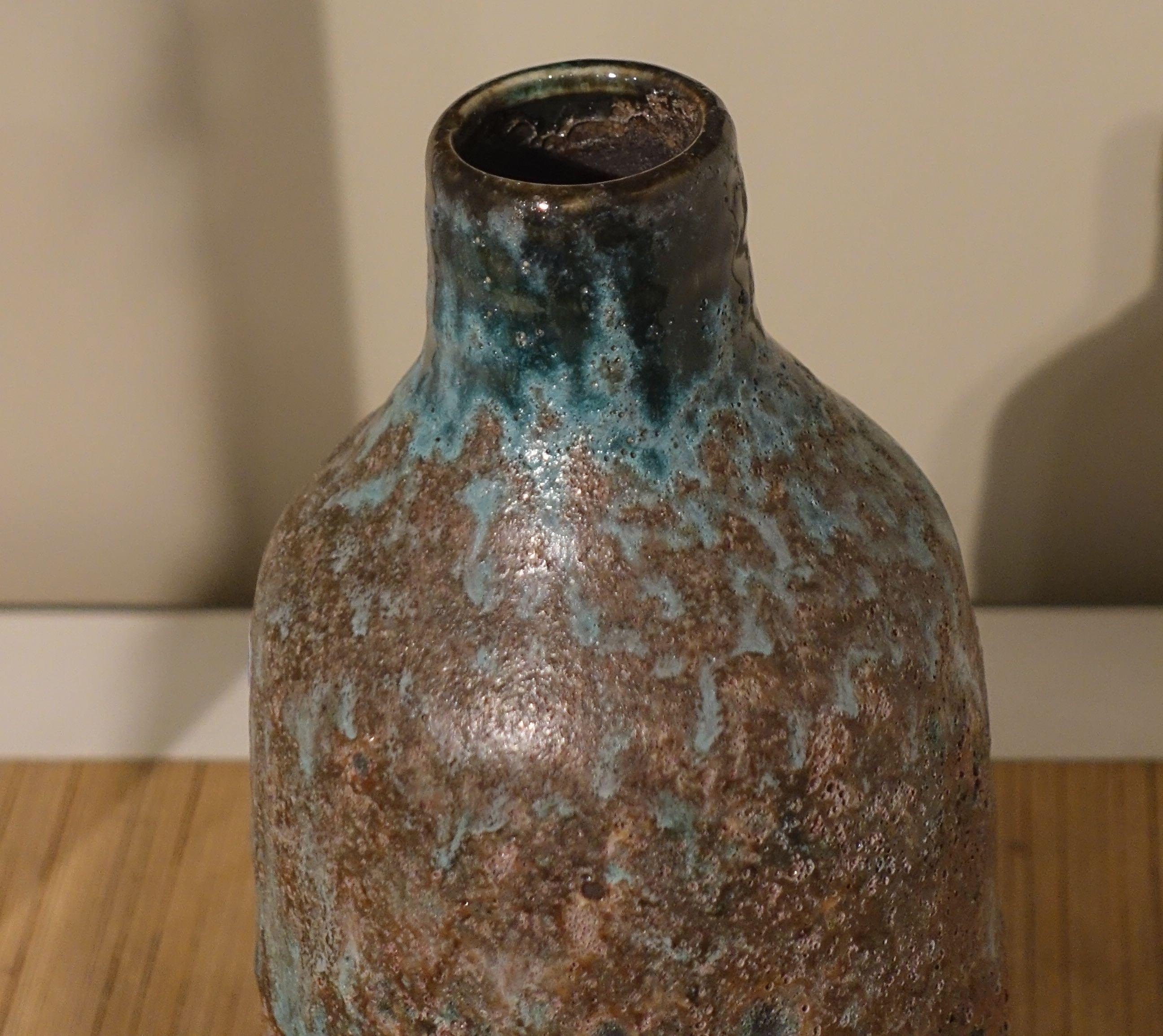 Contemporary Chinese textured volcanic glaze vase with thin mouth and straight neck.
Sits well as part of a collection.
S5141/3/4/5.
 