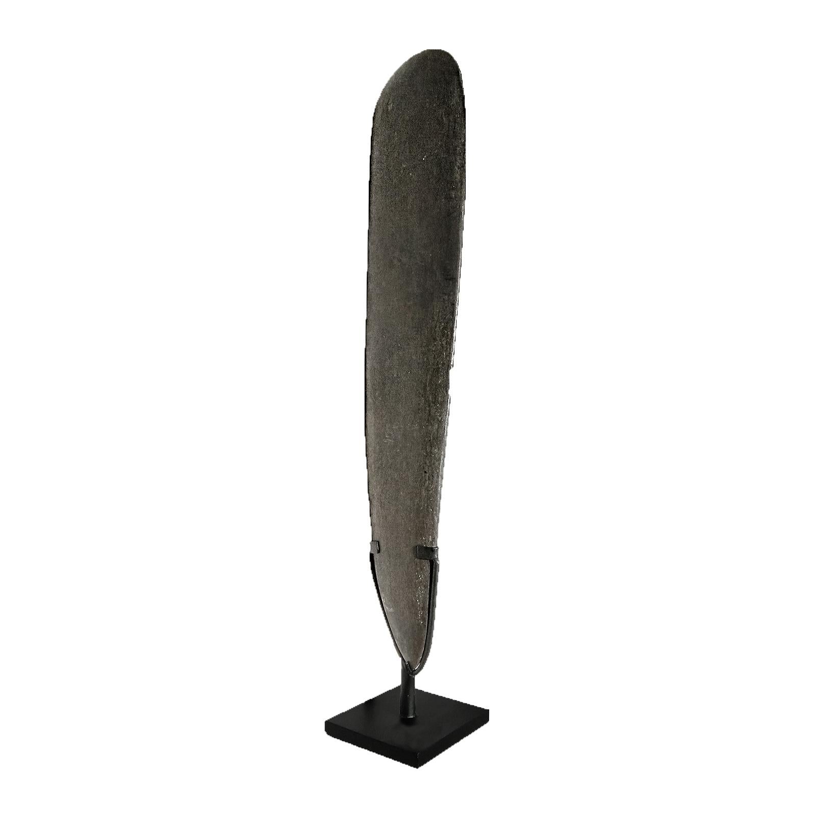 A hand-carved, hand-polished volcanic Basalt blade from Indonesia, late 20th Century. Mounted on a black metal stand. 

34 inches high, 6.5 inches max. wide. Base stand: 5.75