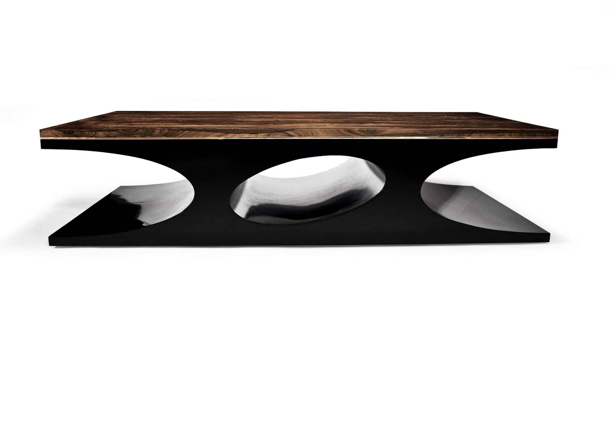 The Volcano Table comprises of High gloss H9 wood top, jeweled and welded bronze trimming, eloquently designed on a black lacquer base. The bold, sleek curvature of the hollowed base paired with the Highly glossed H9 top results, in an explosive yet