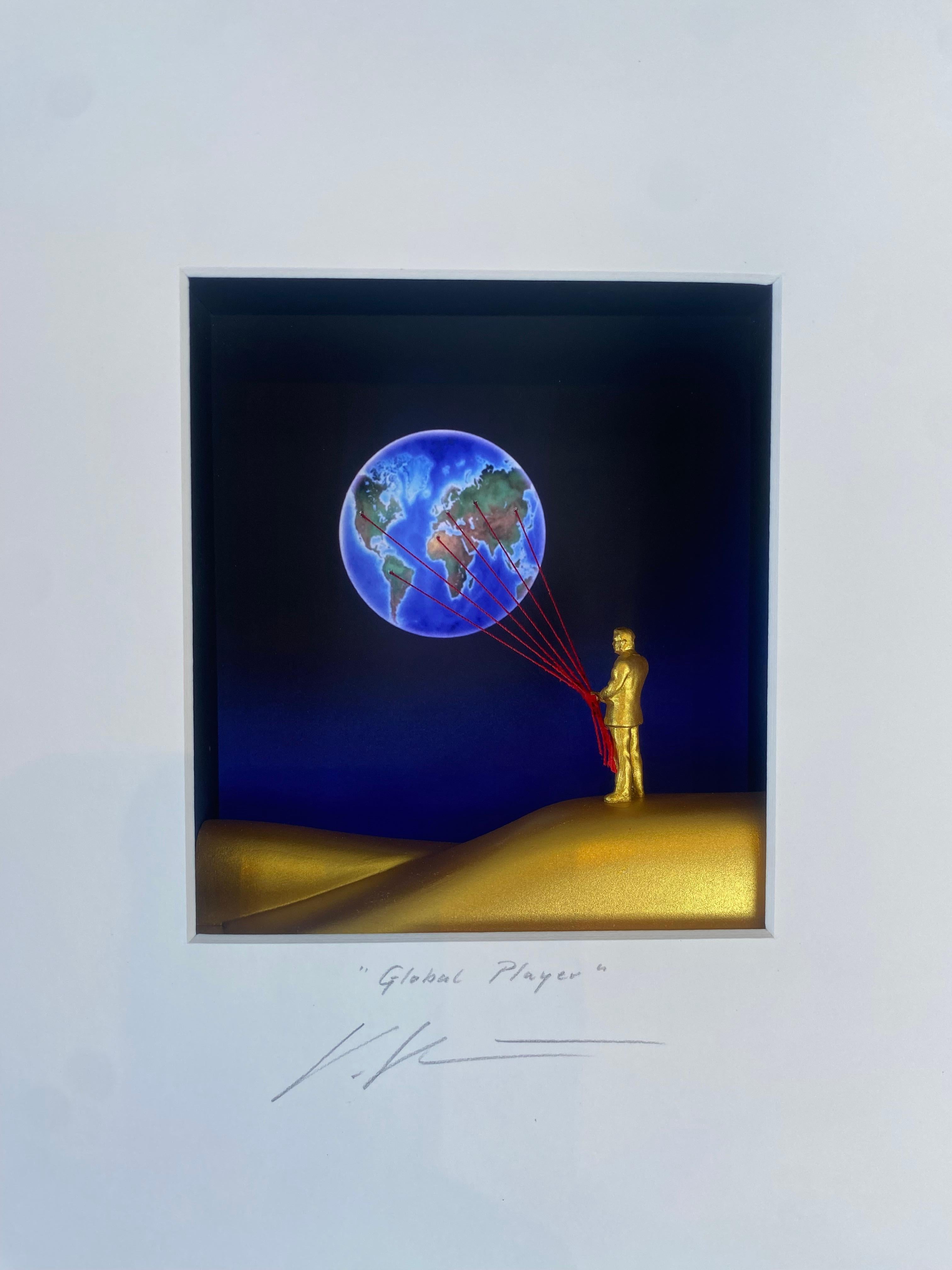 Global Player – zeitgenössische Kunst in Schachteln von Volker Kuhn mit einem Menschen, der einen Globus hält