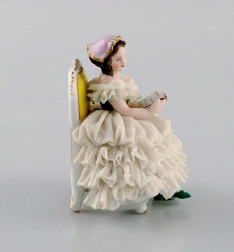 Rudolstadt Volkstedt, Alemania. Figura de porcelana. Mujer lectora con falda. 
Mediados del siglo XX.
Medidas: 7 x 6 cm.
En muy buen estado. Mínimo desconchón en el faldón.
Sellado.