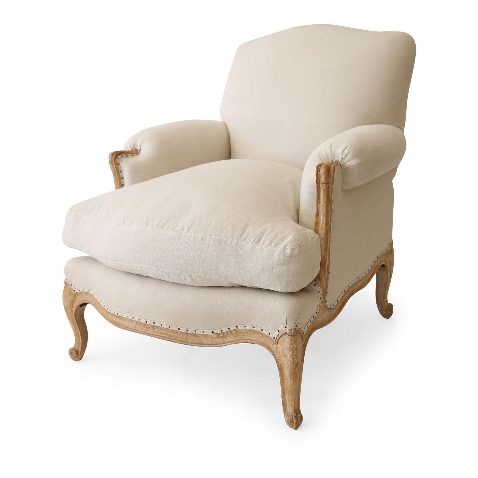 Voluptuous Louis XV bergeres: these generously proportioned early 20th century French armchairs are scraped back to their original cream color painted finish and newly-upholstered in a neutral linen.