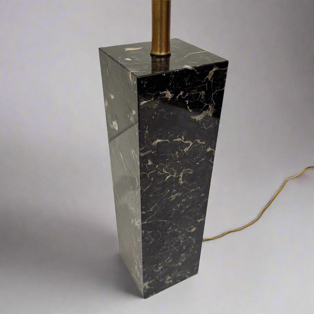 Lampe de table à colonne en marbre noir, d'origine américaine, circa 1950.
Forme rectangulaire en marbre massif et détails en laiton patiné.

Mesures : H 29.75   Abat-jour : 14 pouces.  Colonne en marbre : H : 15.88  W:4.50  D:4.50 pouces.