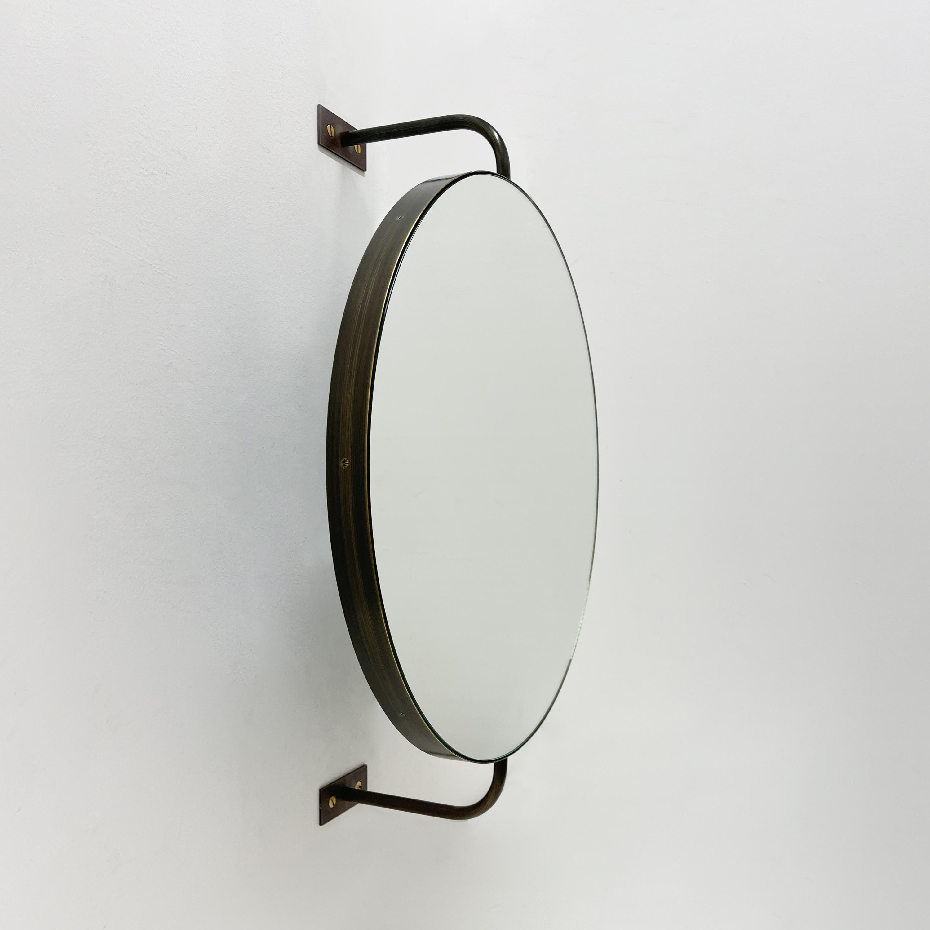 Miroir rond moderne Orbis Vorso™ fixé au mur, doté d'une fonction rotative et d'un cadre en finition laiton patiné bronze. Conçu et fabriqué à Londres, au Royaume-Uni.

Les deux bras sont conçus pour fixer le miroir au mur, non seulement en tant