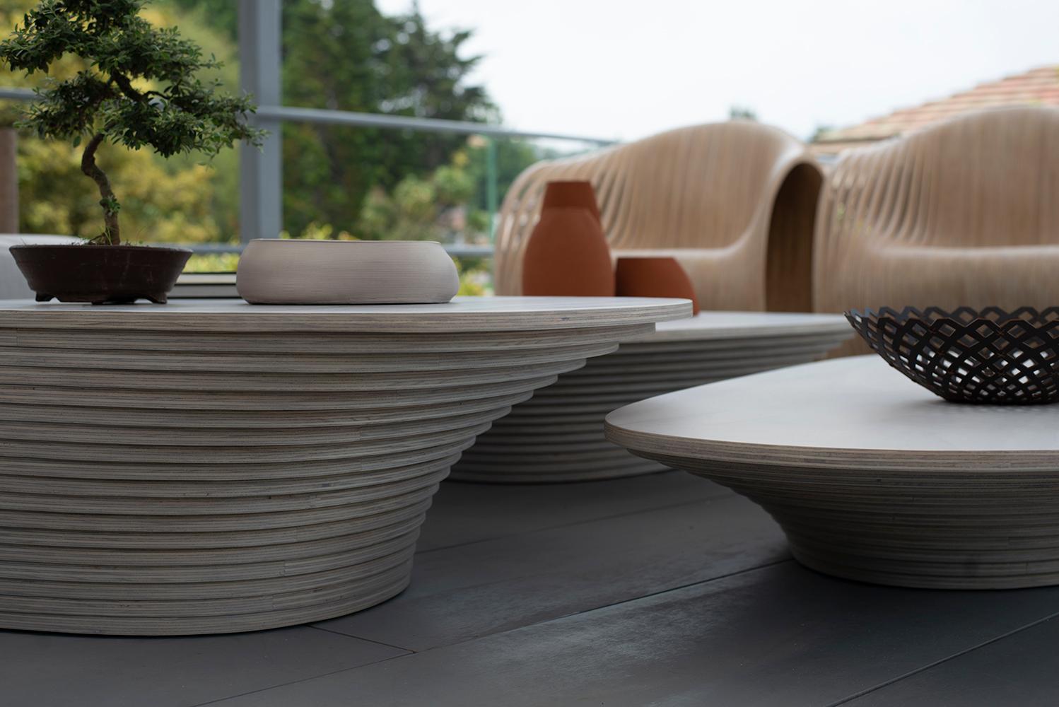 Table réalisée avec des sections horizontales de bois de bouleau et d'épicéa stratifié (18,5 mm d'épaisseur chacune). Finition mate avec teinture et revêtement extérieur en polyuréthane. Il s'inspire de la forme d'un vortex en spirale, avec une