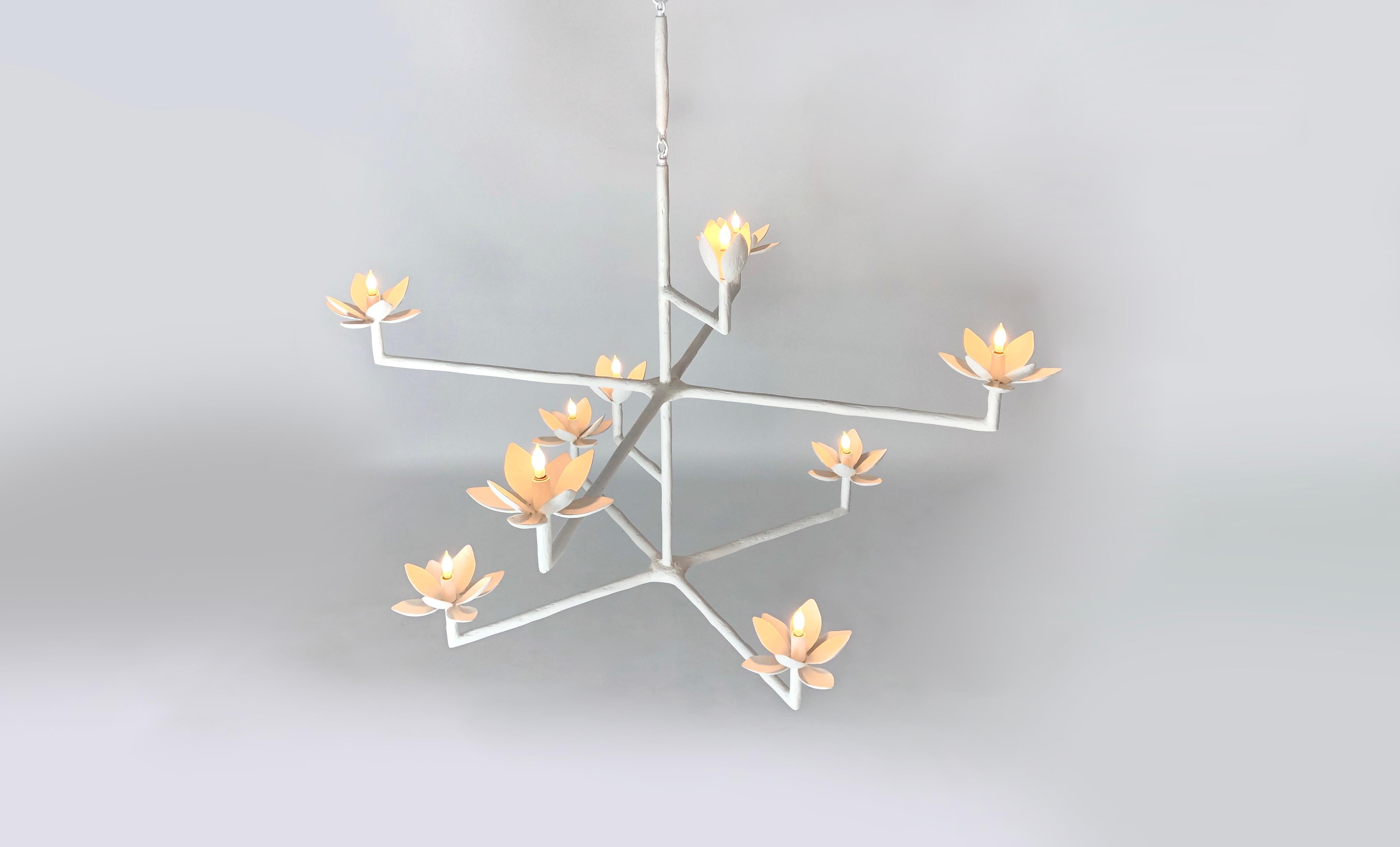 The magnolias are in bloom. In their various stages, the blossoms conceal the lights of this asymmetrical chandelier. The textured plaster of Paris finish on its stately frame creates a chandelier perfect for the foyer or above a dining table. With