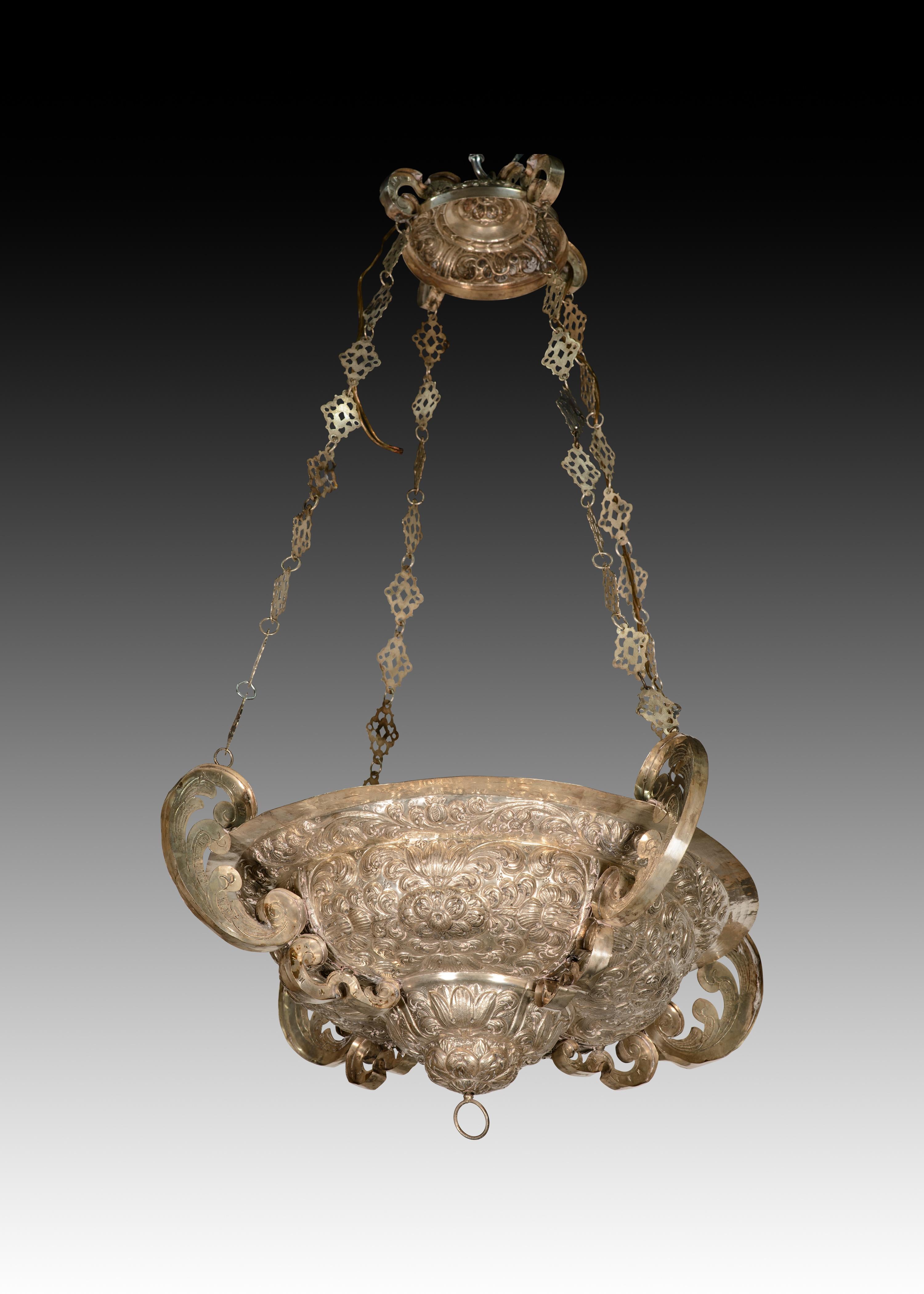  Lampe votive. Couleur argentée. École espagnole, 18e siècle. 
Avec des marques de contraste. 
Plafonnier en métal argenté composé de deux pièces reliées par des chaînes ajourées à maillons rhomboïdaux alternant avec des anneaux. Ces deux éléments