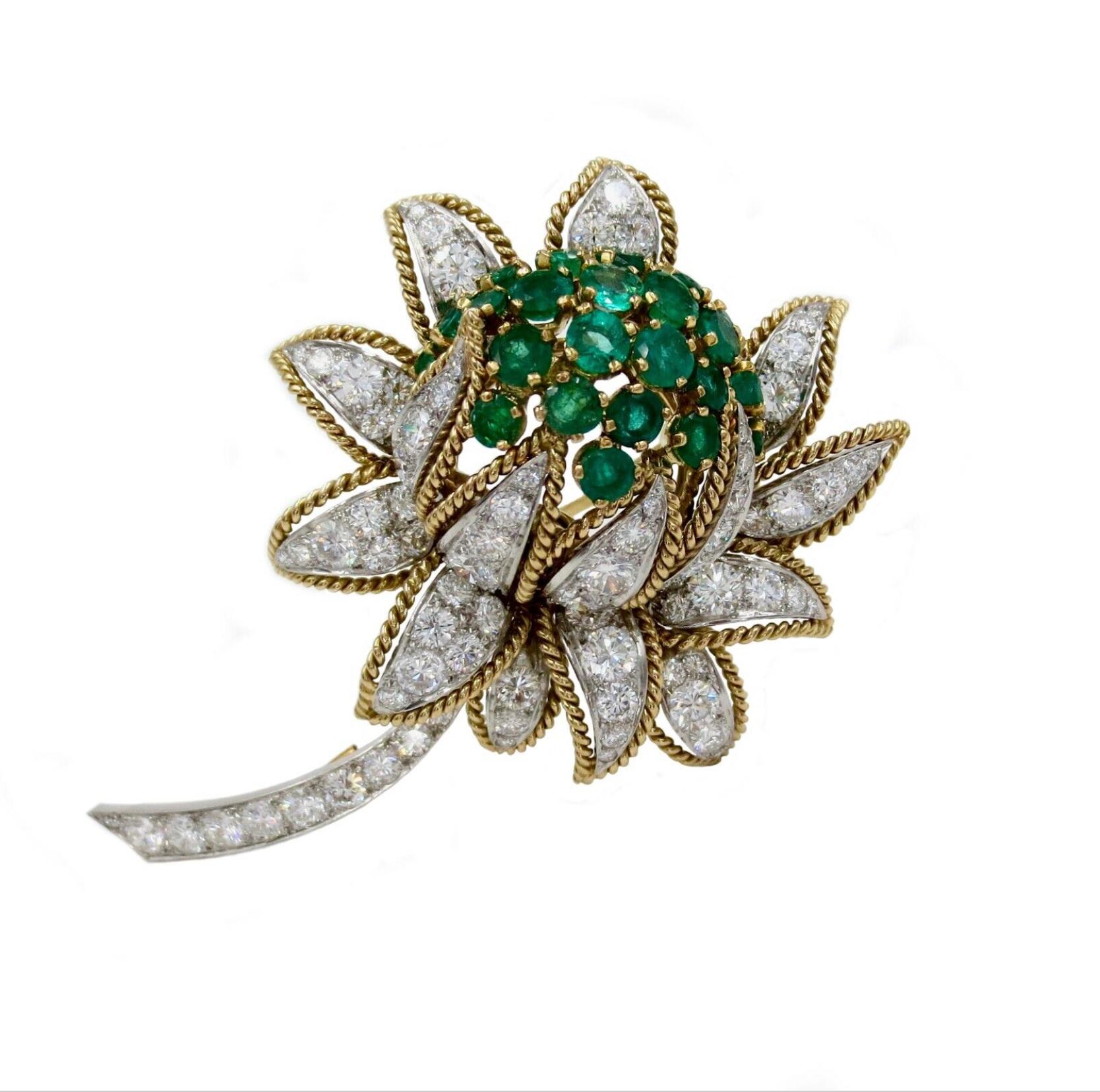 This stunning, 1960-1970's diamond and emerald earrings and brooch set by Vourakis is crafted in 18k white and yellow gold.

Brooch is design as a blooming flower on the stem, encrusted with approx. 7.15ct. diamonds, 3.20ct. emeralds and accented
