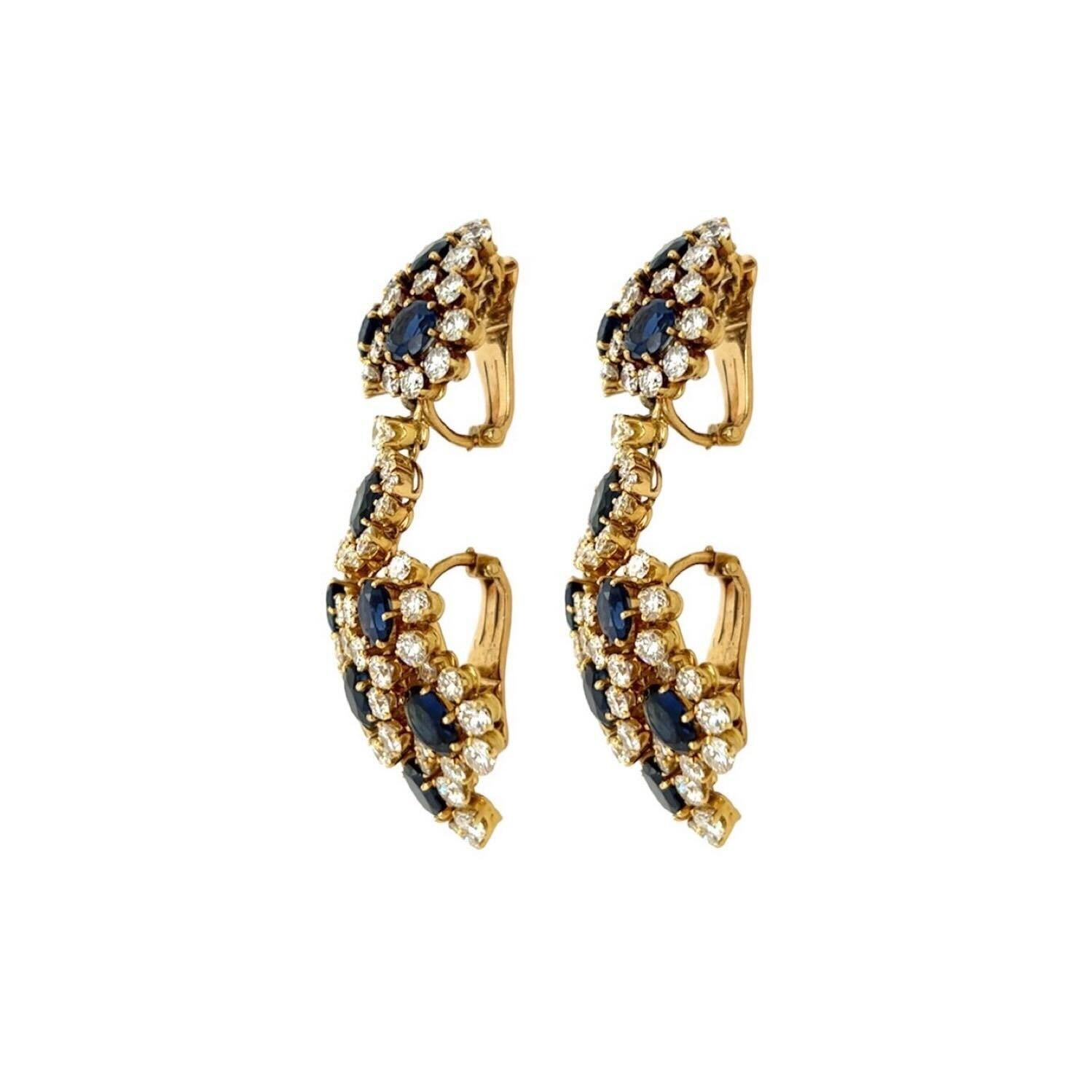 A pair of 18 karat yellow gold, sapphire and diamond earclips, Vourakis.  Each earclip designed as a trio of faceted round sapphires measuring approximately 5.23 mm., each sapphire surrounded by diamonds, the whole suspending a navette shaped