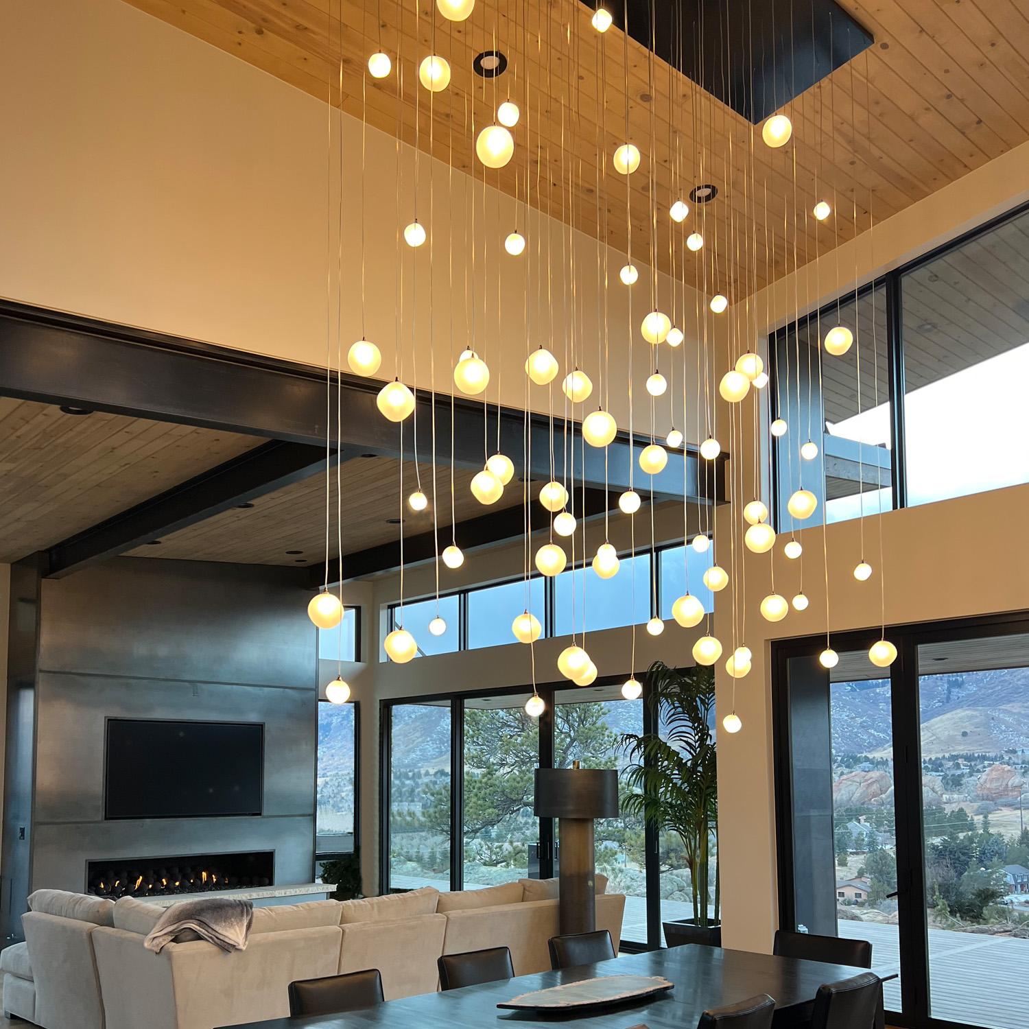 Introducing the Voyage cluster asymmetrical pendant chandelier - a stunning addition to any modern home or commercial space. This hand-blown artisanal glass light fixture boasts a unique design that is sure to capture the attention of all who enter