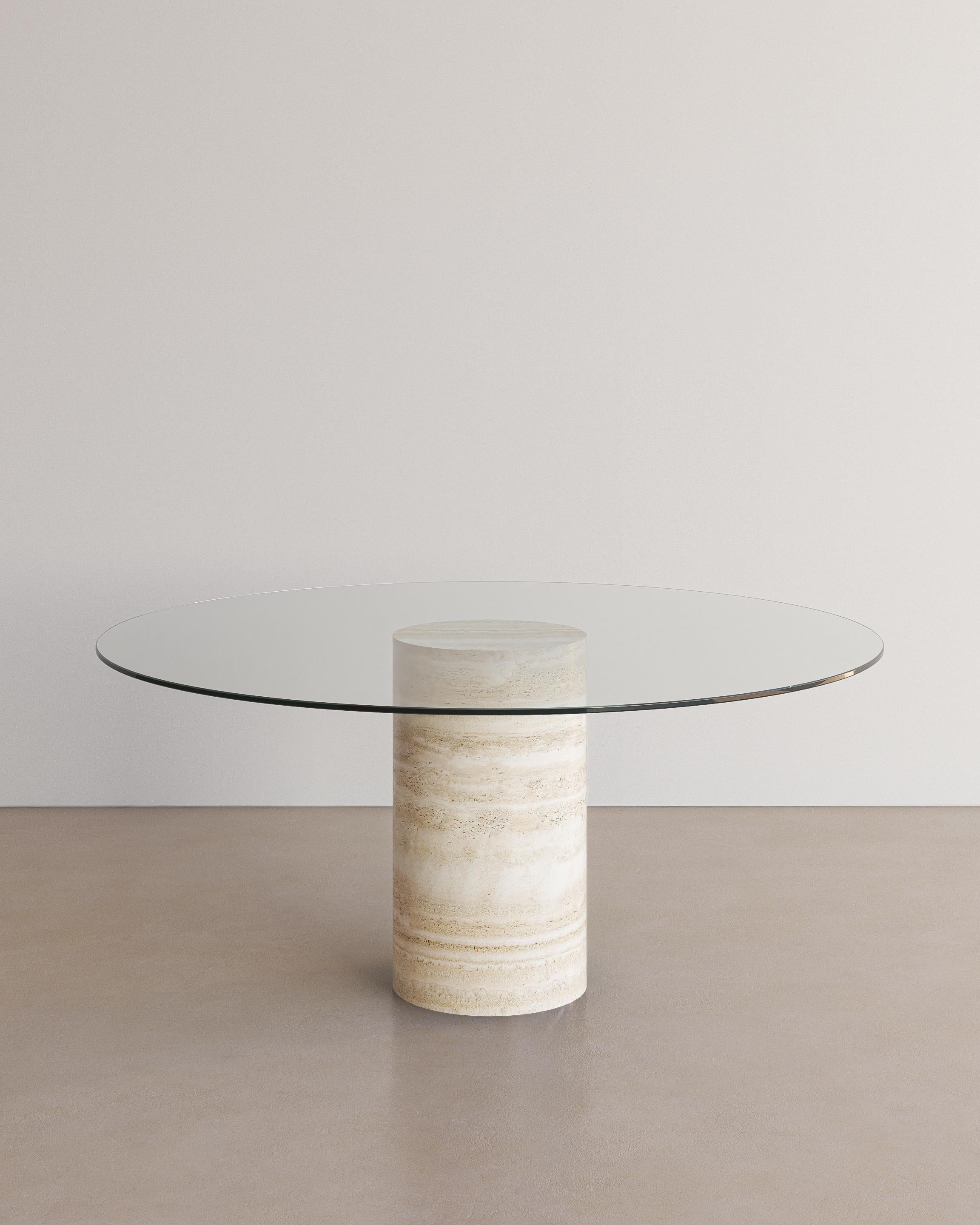 Unveiling the Voyage Dining Table I (Glass) by The Essentialist. An embodiment of modern sophistication meeting organic allure. The ethereal quality of the crystal-clear glass top subtly enhances the standout feature: a pedestal crafted from natural