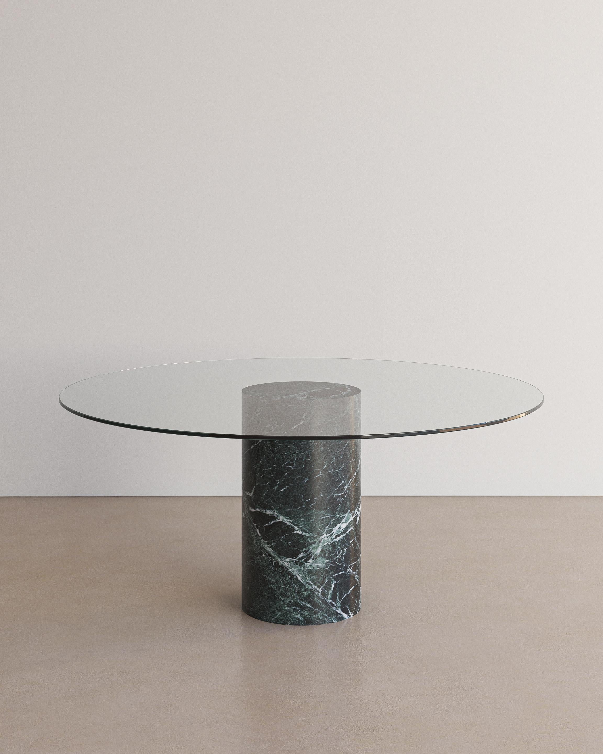 Unveiling the Voyage Dining Table I (Glass) by The Essentialist. An embodiment of modern sophistication meeting organic allure. The ethereal quality of the crystal-clear glass top subtly enhances the standout feature: a pedestal crafted from natural