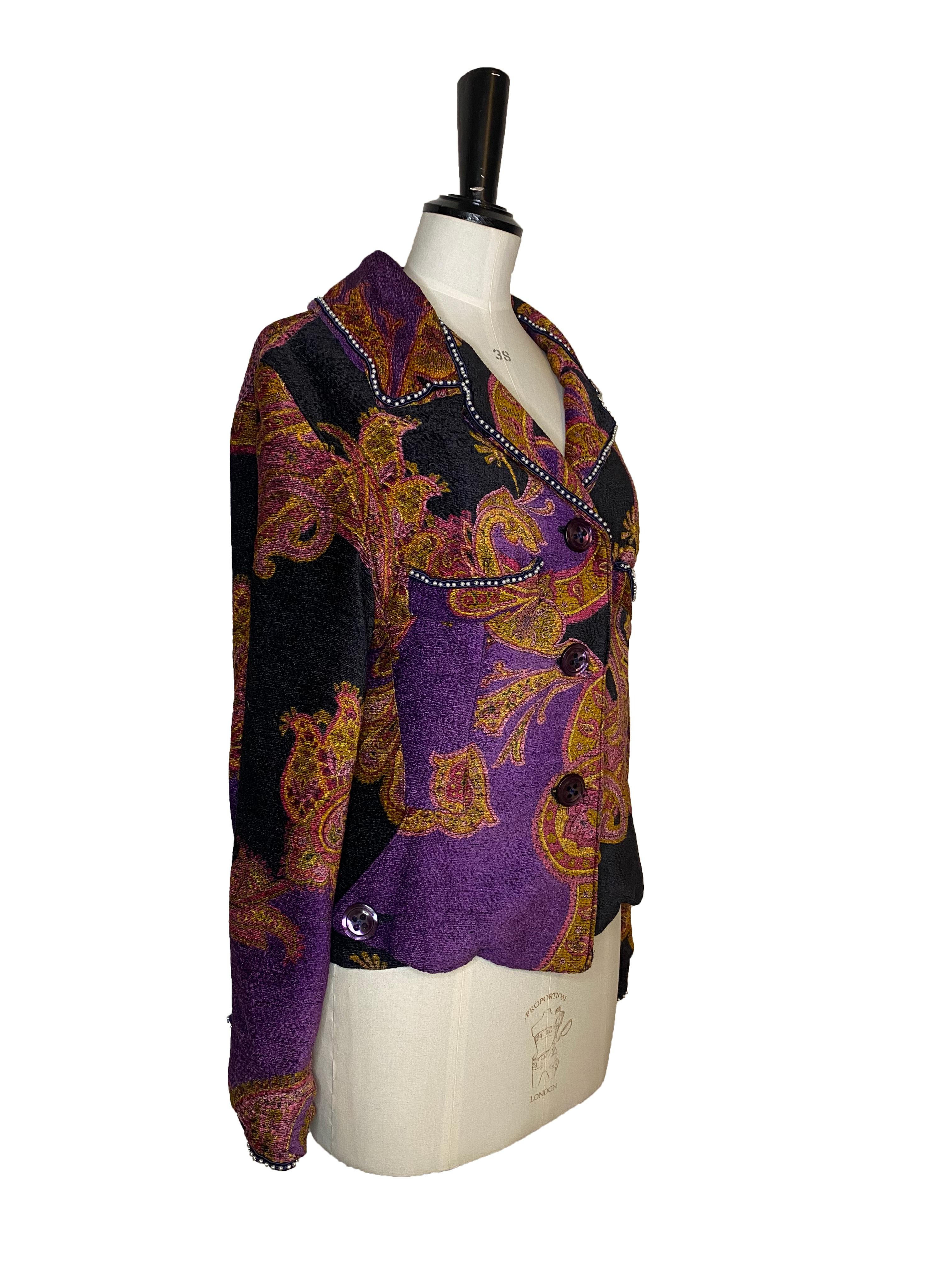 Vintage Paisley pattern jacket from Voyage Invest in the Original. Purple and black cotton mix upper with vivid pink and ochre Paisley pattern and purple pearlescent buttons. Embellished with faux pearl trim around the cuffs, collar, breast pockets