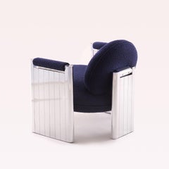 VOYAGER armchair, navy blue bouclé upholstery, mirror-polished metal structure.