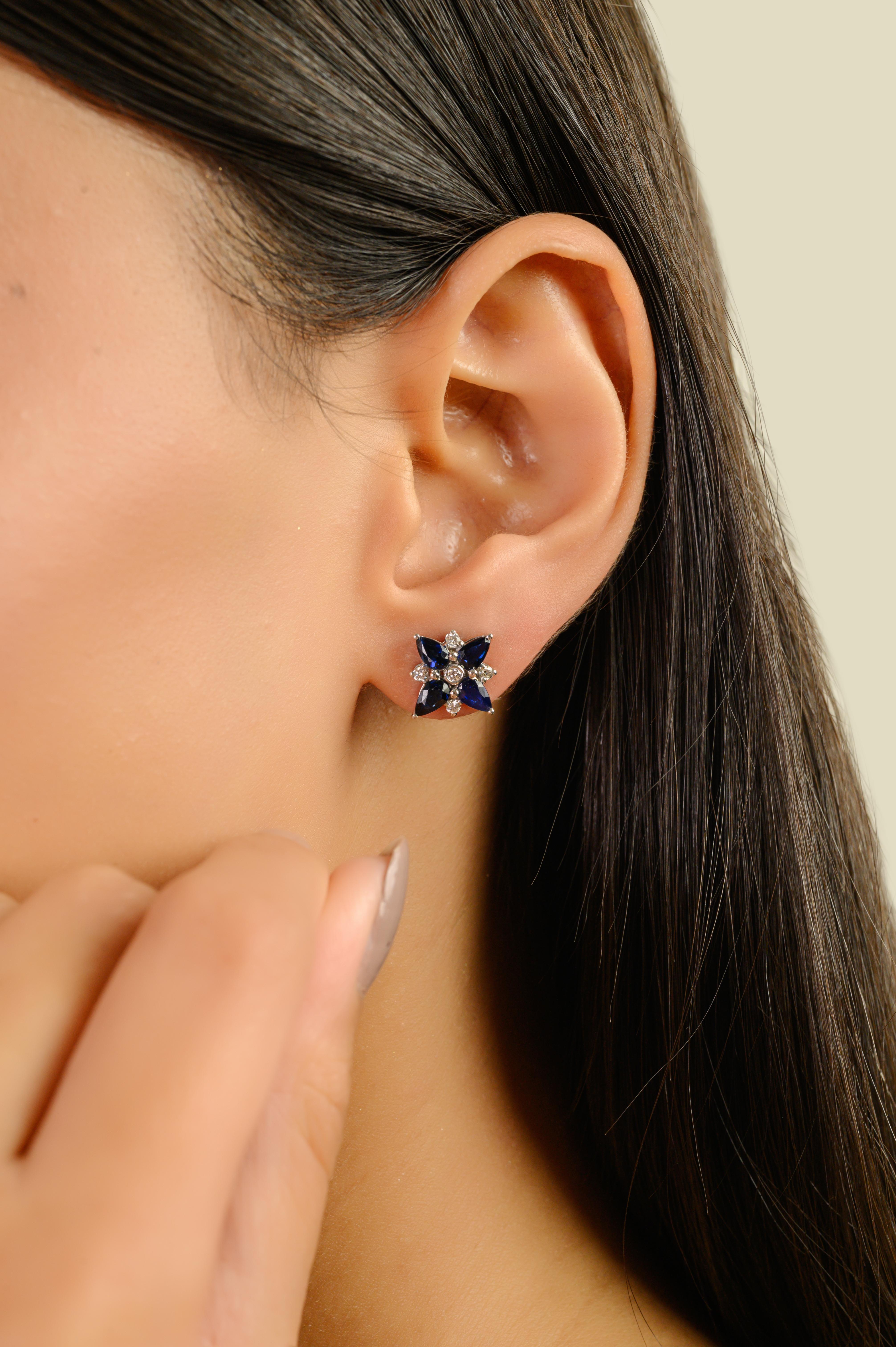 Ces superbes boucles d'oreilles florales présentent 8 saphirs bleus taille poire totalisant 1,9 carats, magnifiquement sertis dans de l'or blanc 14K. Chaque saphir, mesurant environ 4,5×3 mm, est gracieusement entouré d'un halo de 10 diamants ronds