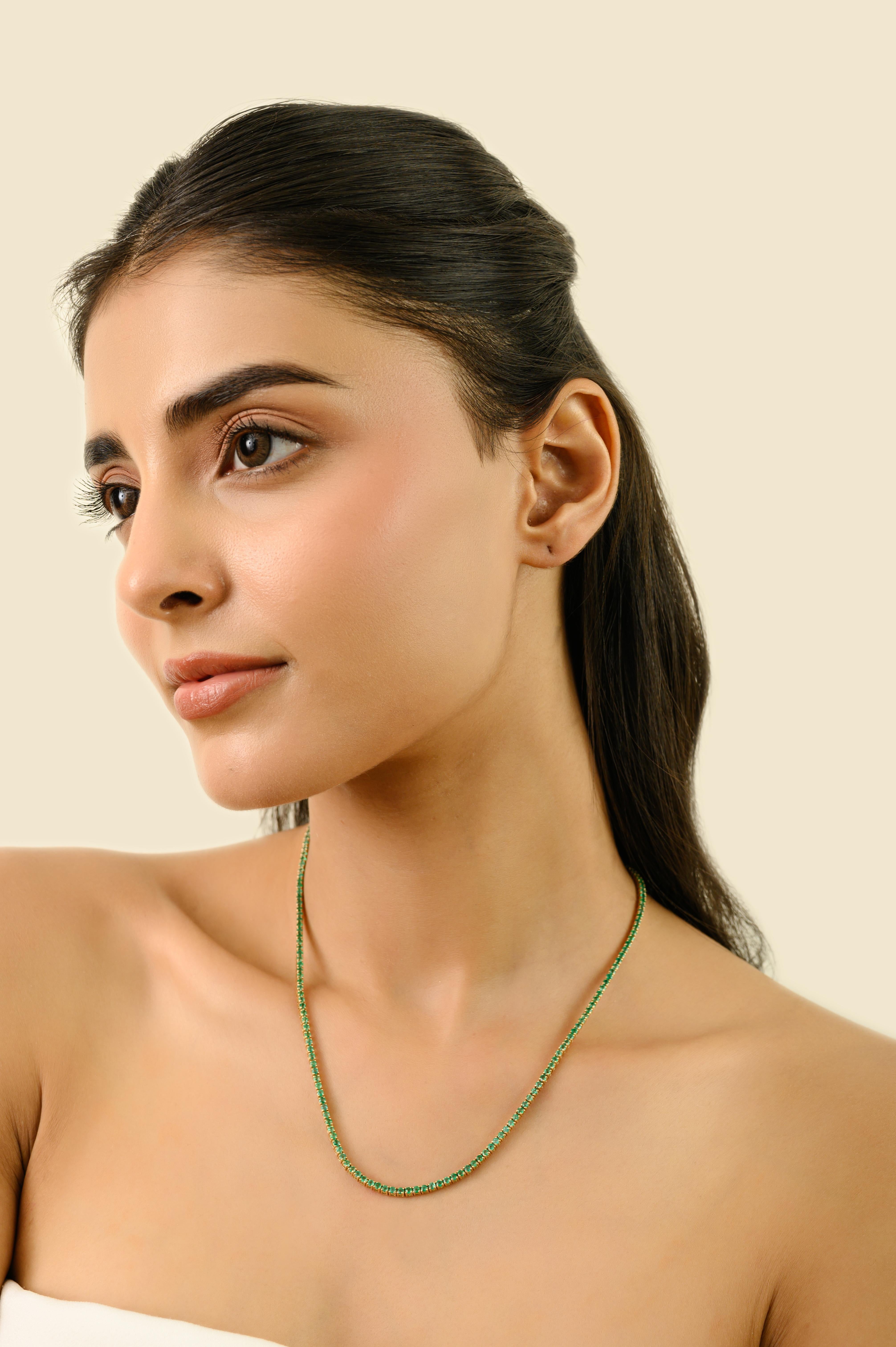 Este impresionante collar tenis exhibe esmeraldas naturales de talla redonda que suman 6,82 quilates, bellamente engastadas en lujoso oro amarillo de 14 quilates. Cada esmeralda, de aproximadamente 2 mm de diámetro, está sujeta con seguridad por